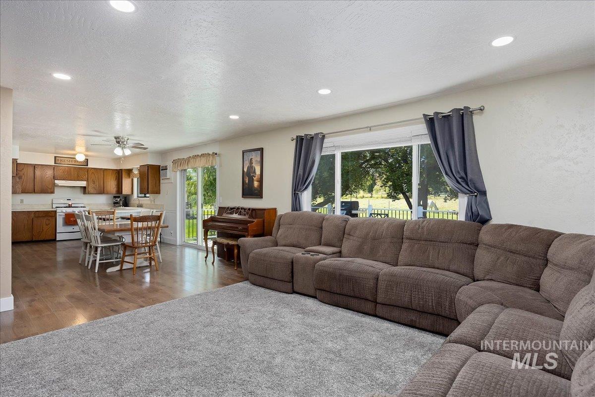 Living area with dark wood-style flooring, recessed lighting, a ceiling fan, and a textured ceiling