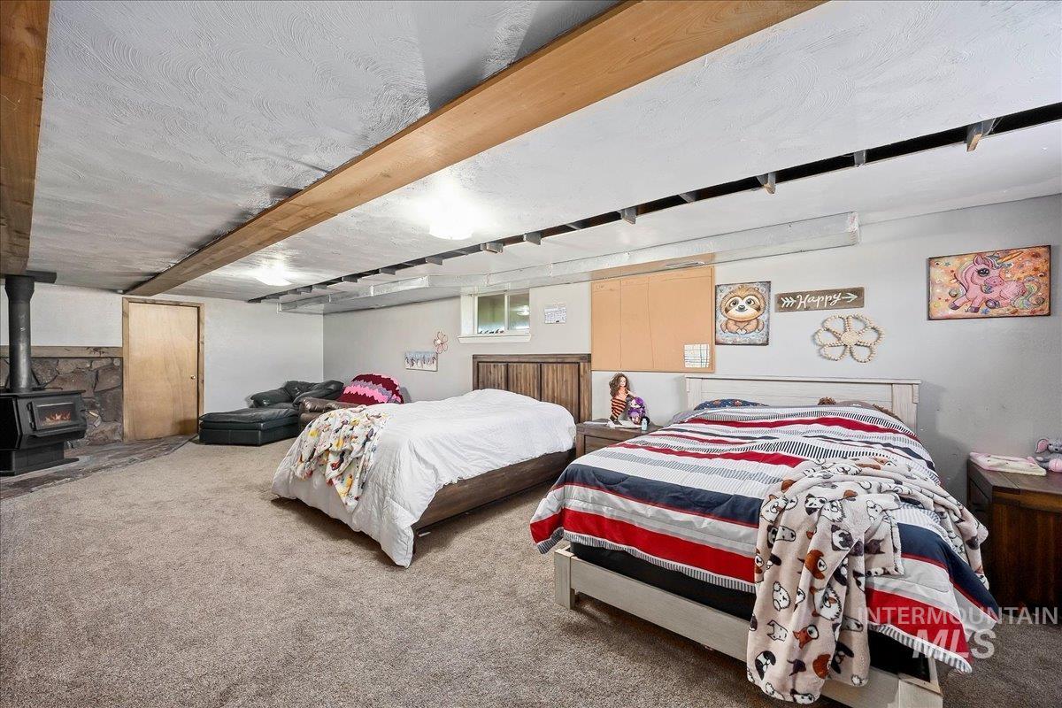 Carpeted bedroom featuring a wood stove