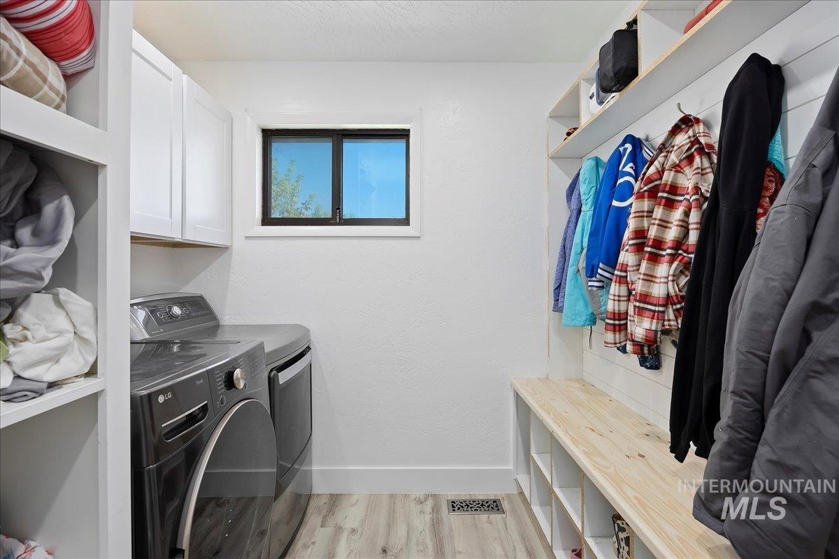 Washroom featuring light wood-style flooring and washer and dryer