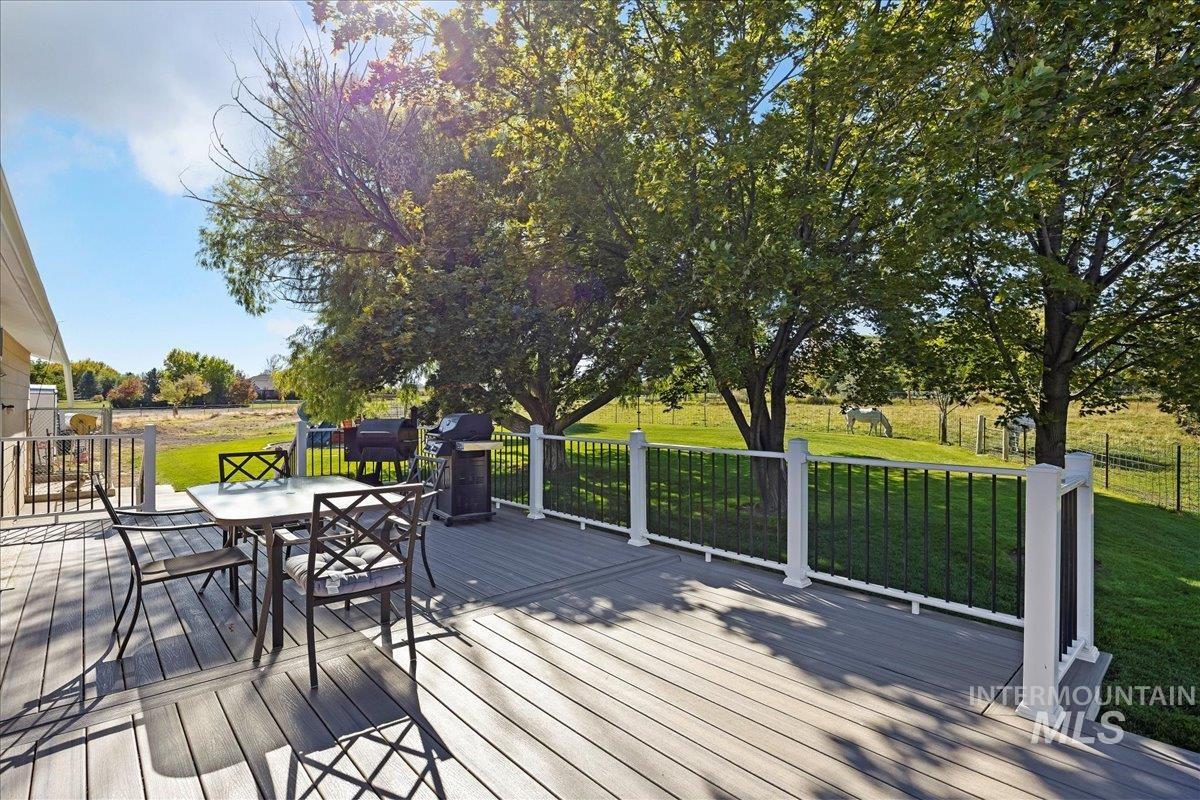 Wooden terrace with a yard, outdoor dining space, and grilling area