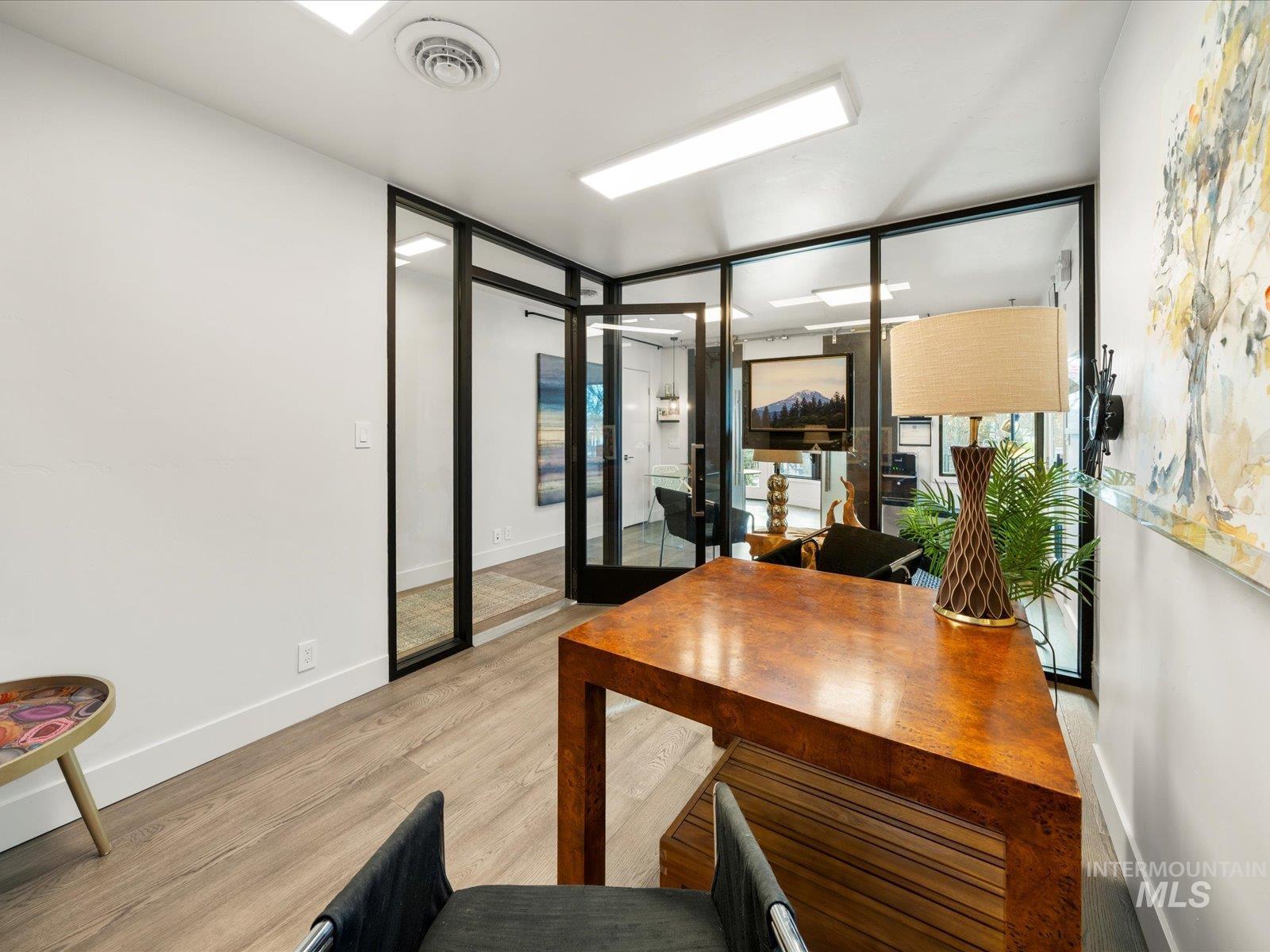 Home office with light wood finished floors and baseboards
