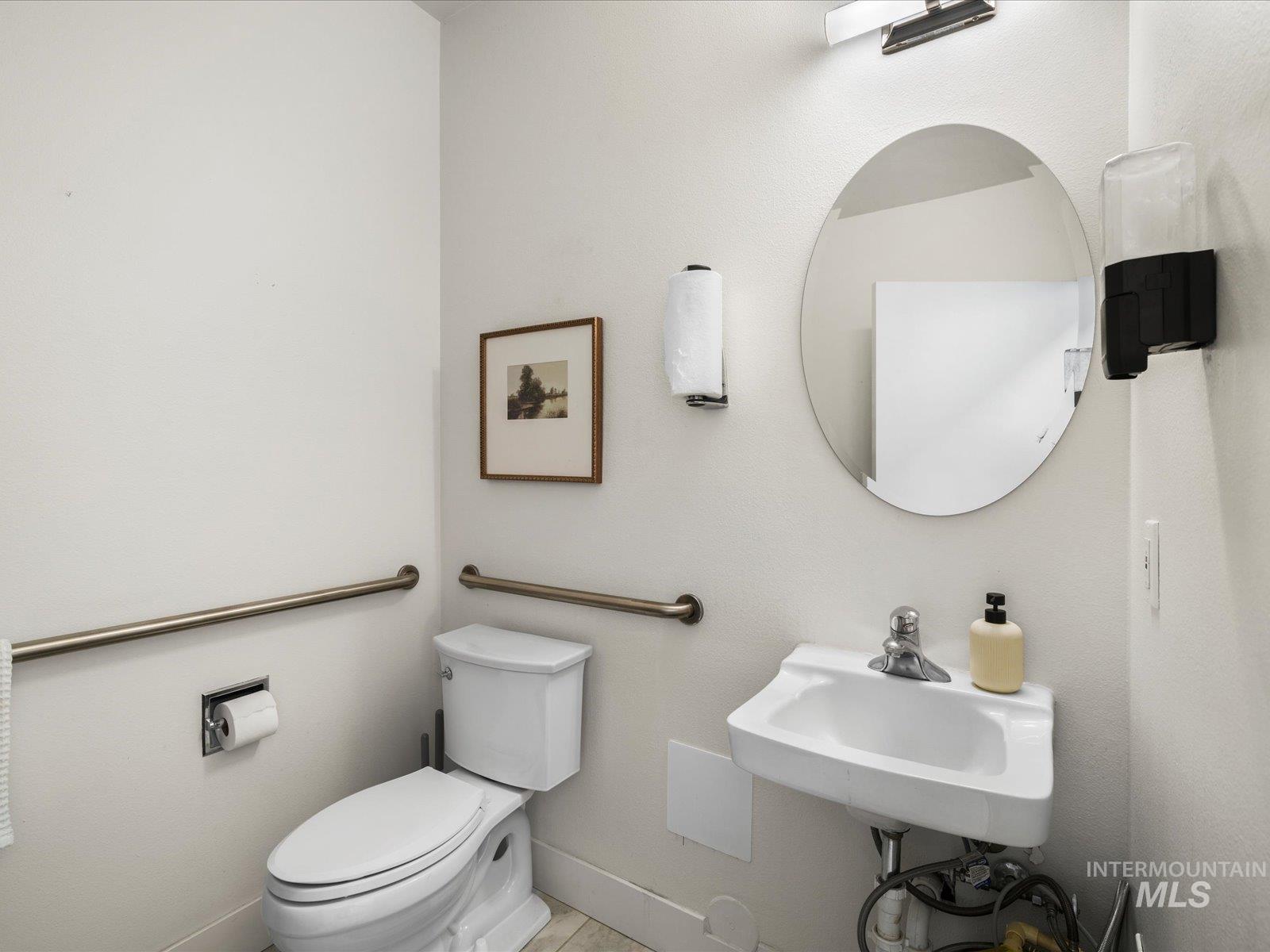 Half bathroom with toilet and baseboards