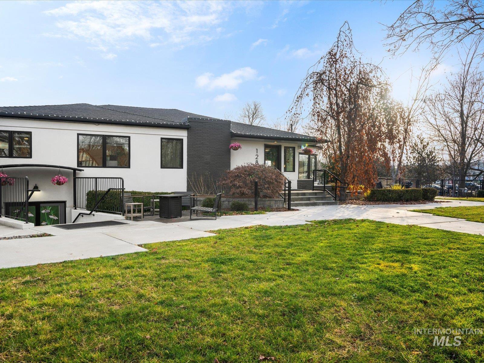 View of front of property with a front yard, stucco siding, and a patio area