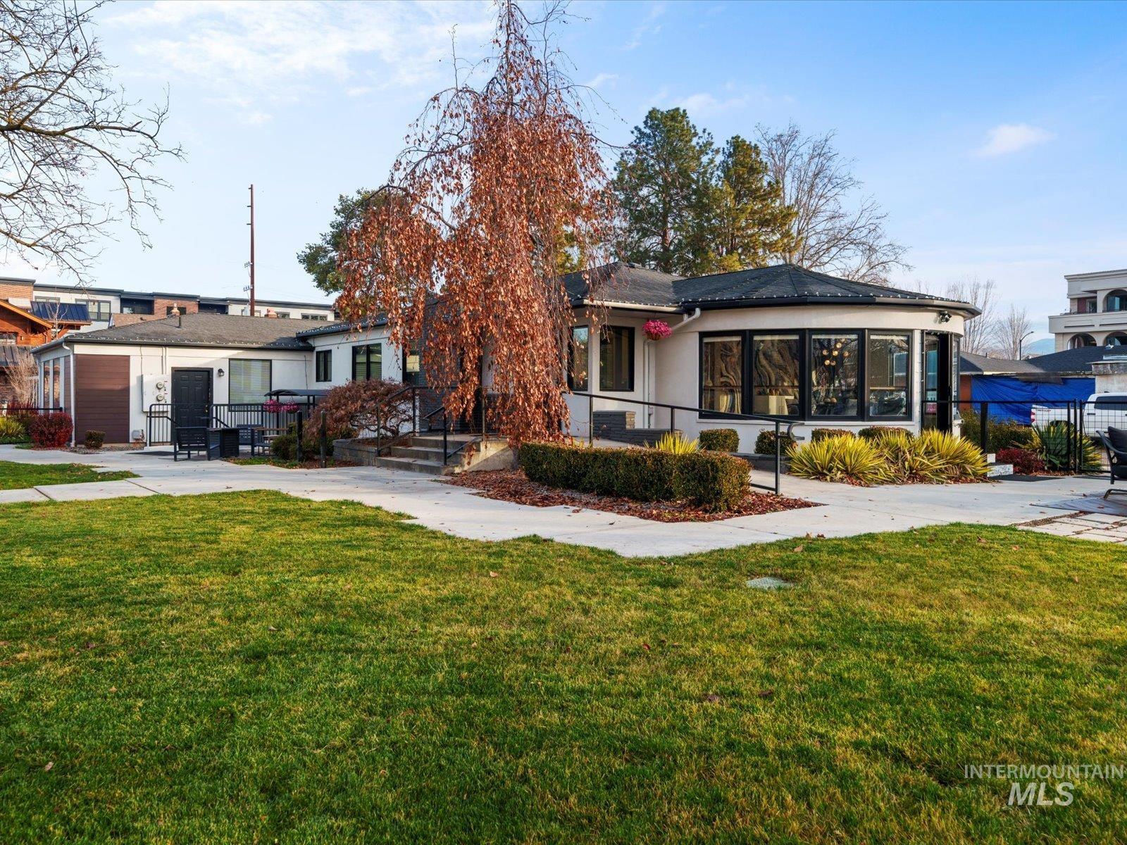 View of front facade with a front lawn and stucco siding