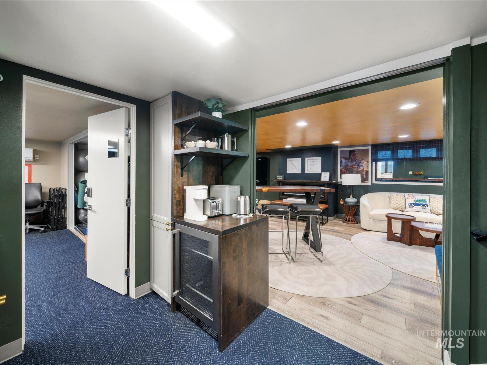 Kitchen featuring an office area, wine cooler, open shelves, and dark countertops