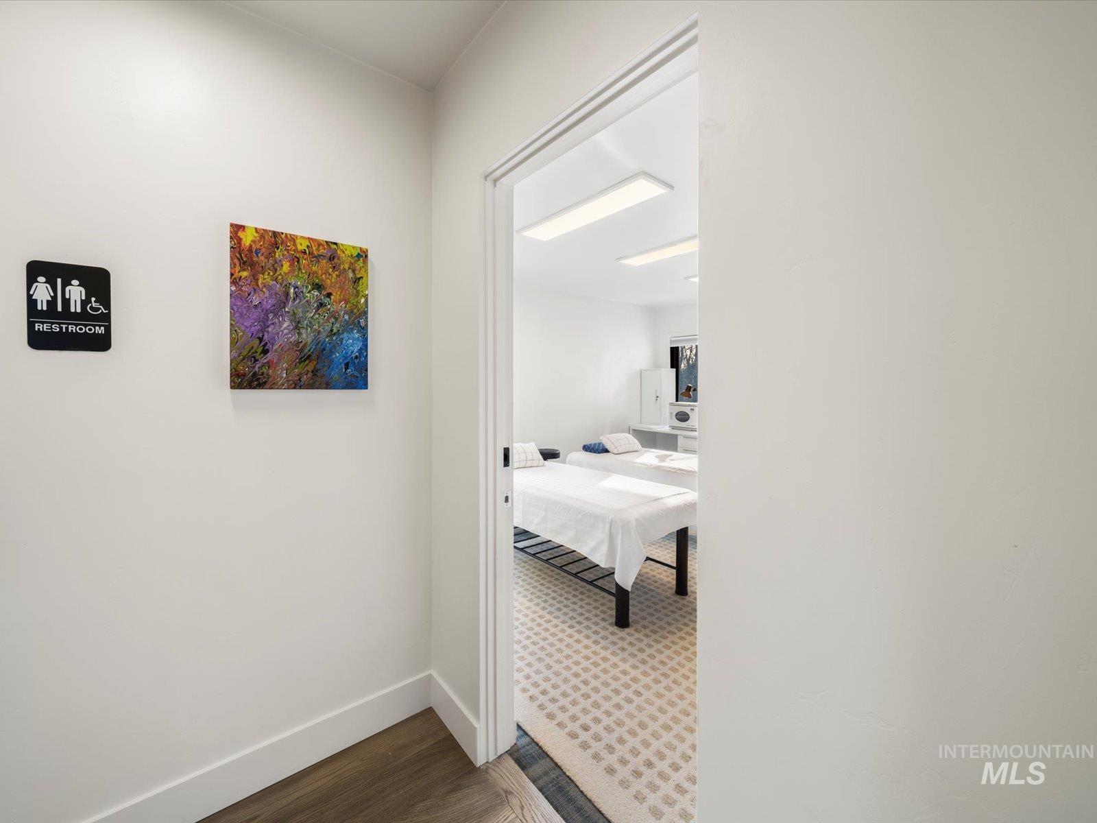 Hall featuring dark wood-style flooring and baseboards