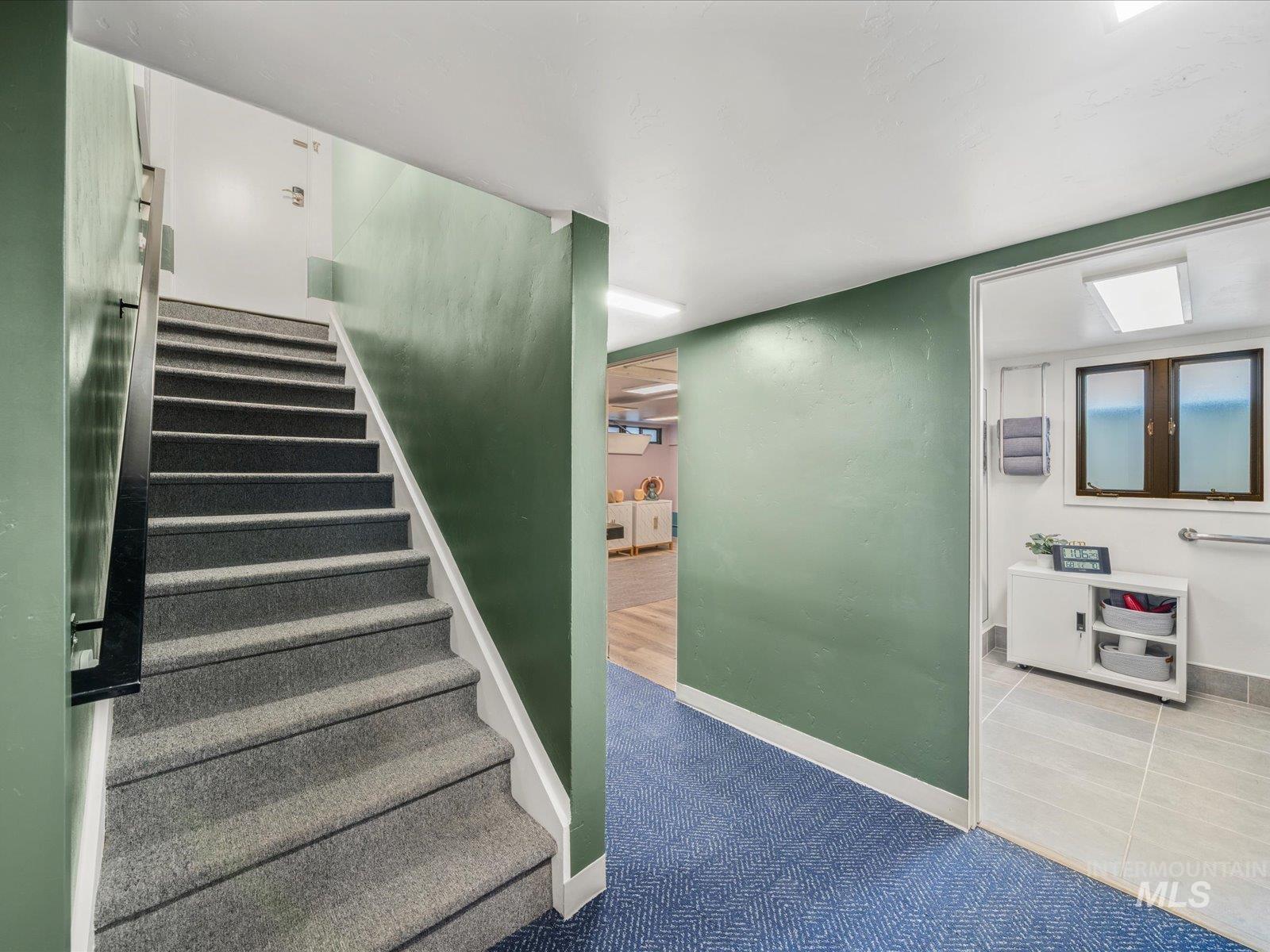Stairway featuring carpet floors and tile patterned floors