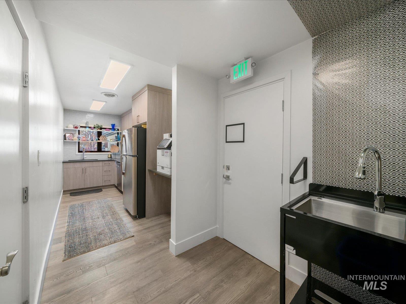 Kitchen featuring light brown cabinets, freestanding refrigerator, and modern cabinets