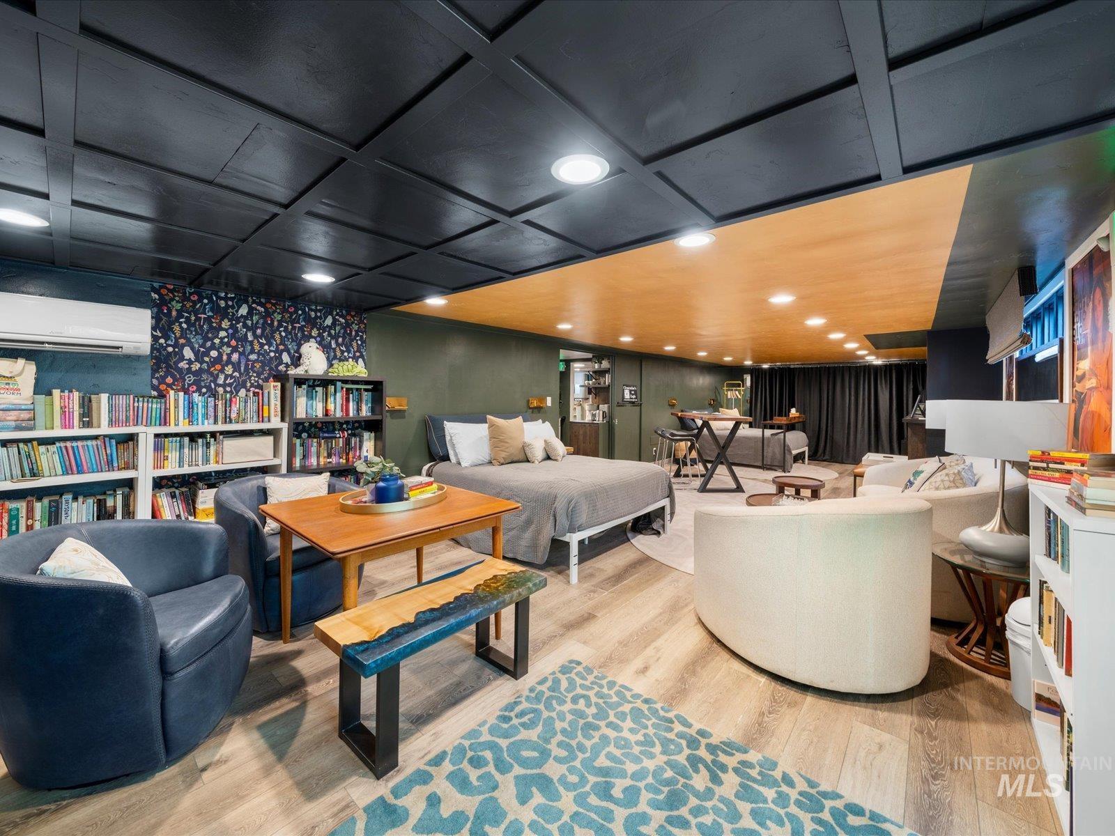 Sitting room featuring light wood-type flooring and a wall mounted air conditioner