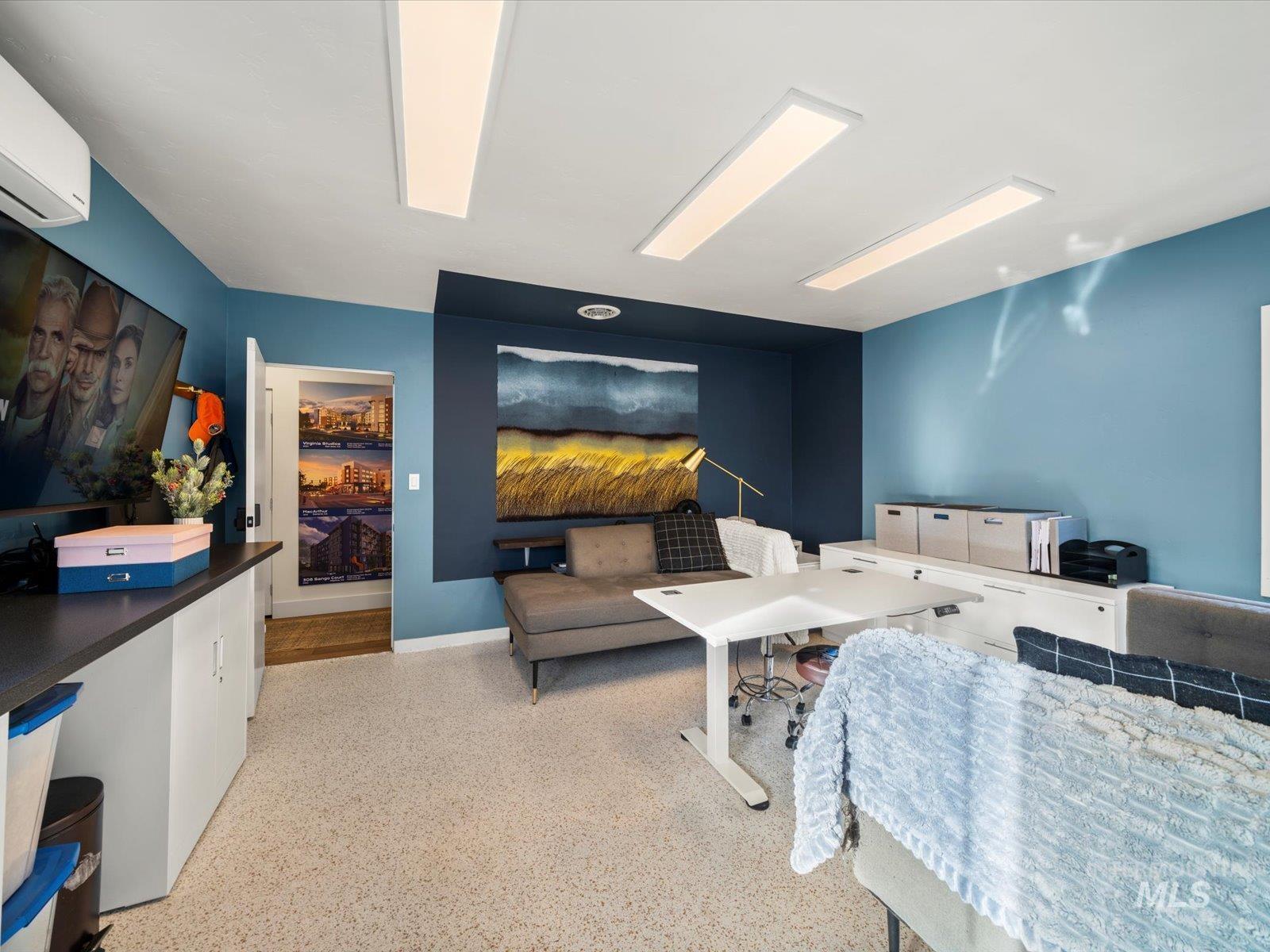 Bedroom featuring dark aggregate flooring and a wall mounted AC