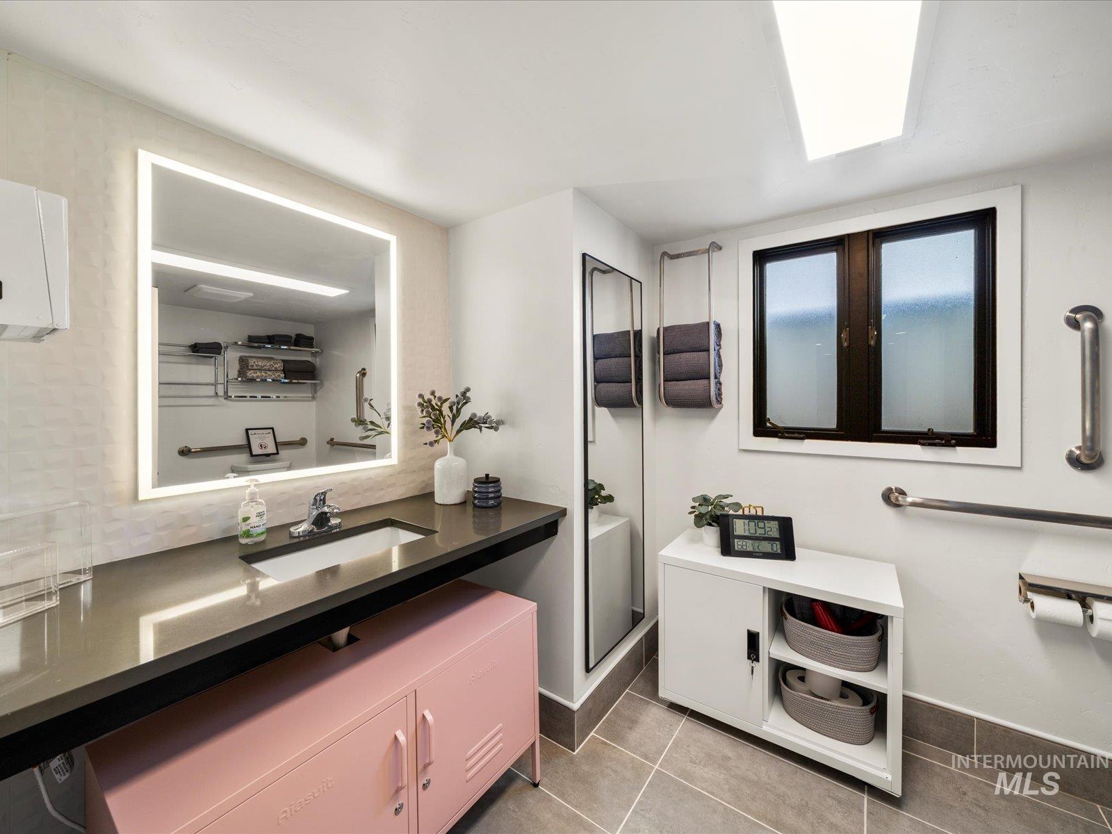 Full bathroom with light tile patterned floors and vanity