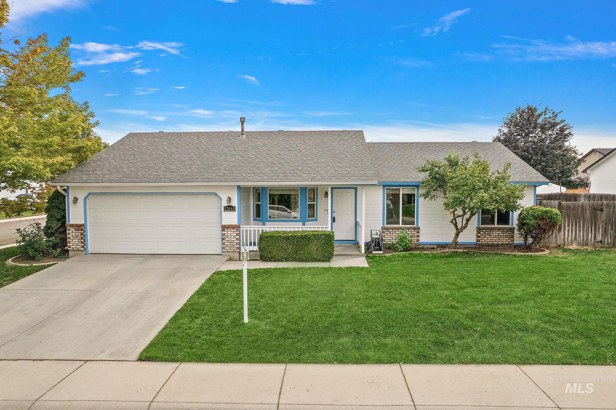 Single story home featuring covered porch, roof with shingles, brick siding, and driveway
