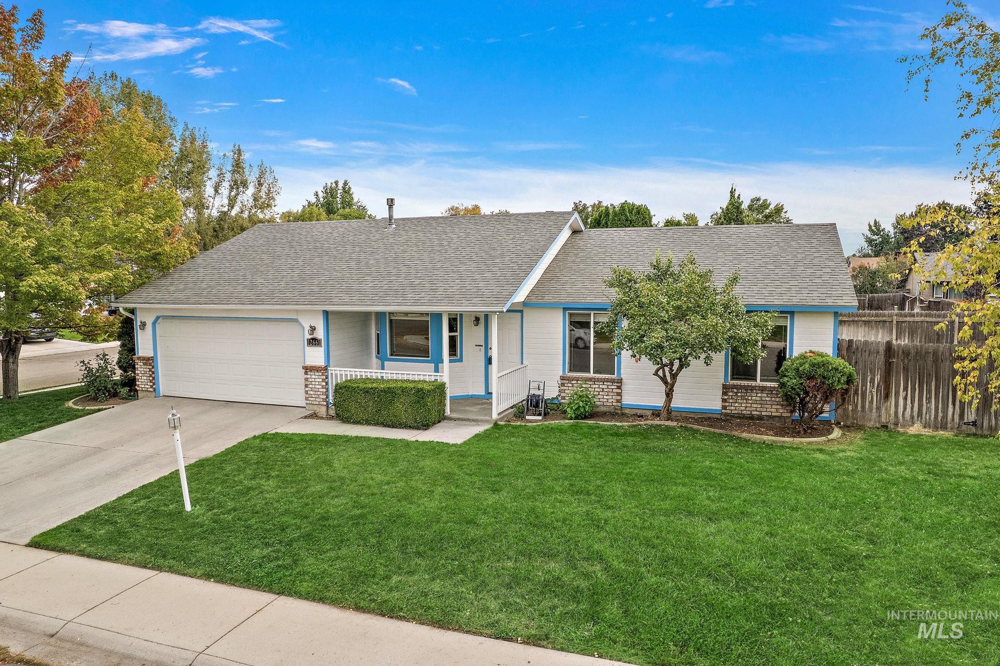 Ranch-style home featuring a porch, driveway, brick siding, and a shingled roof