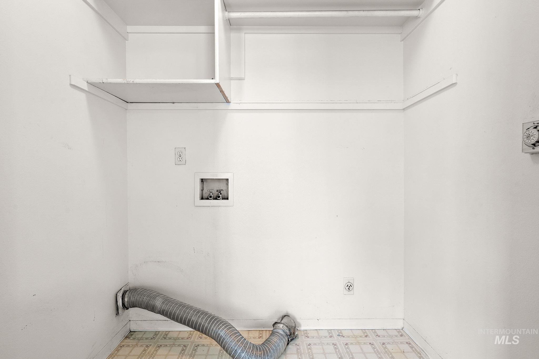 Laundry area with tile patterned floors, washer hookup, and hookup for an electric dryer