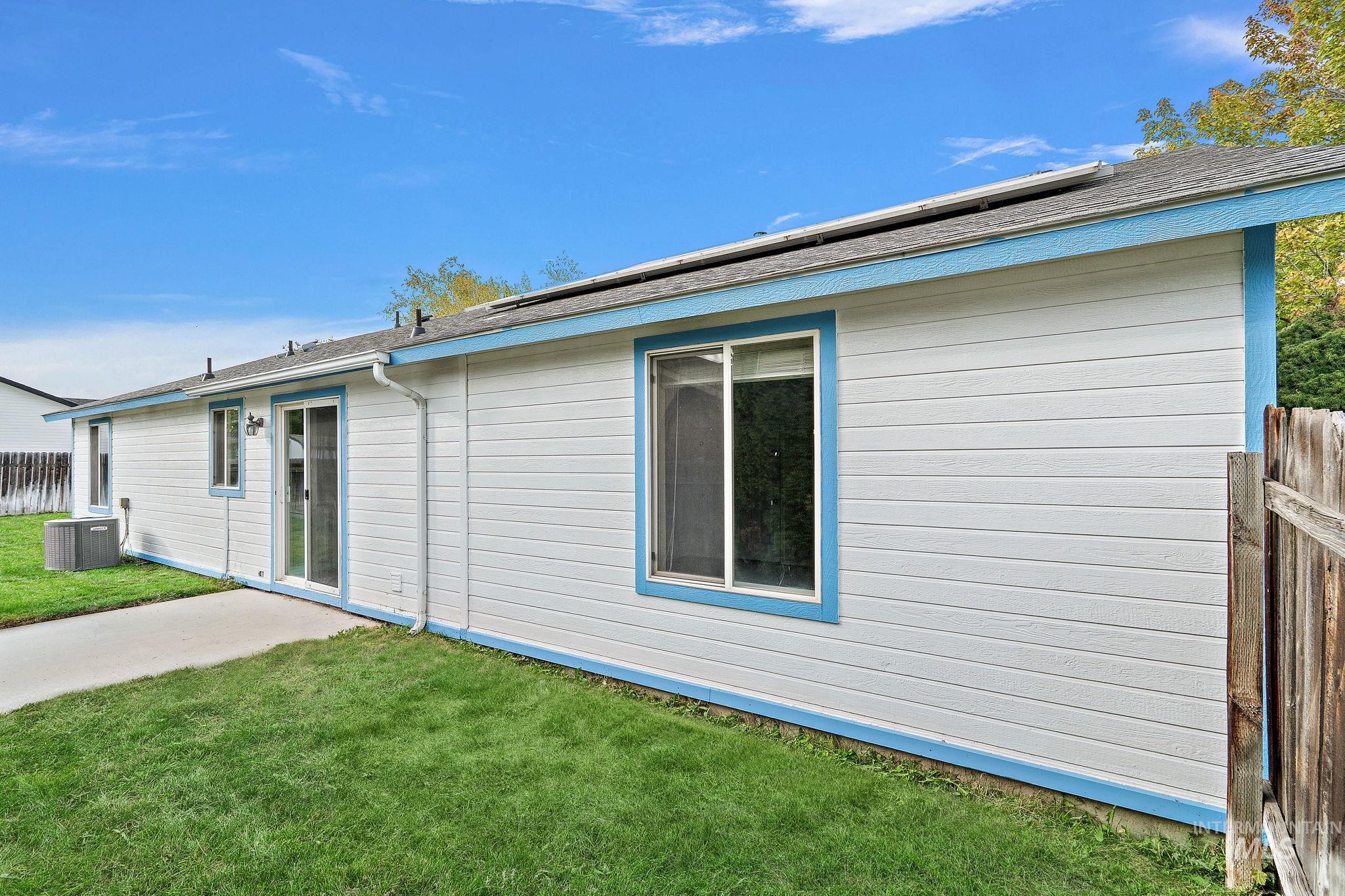 Back of house with a patio area and a shingled roof