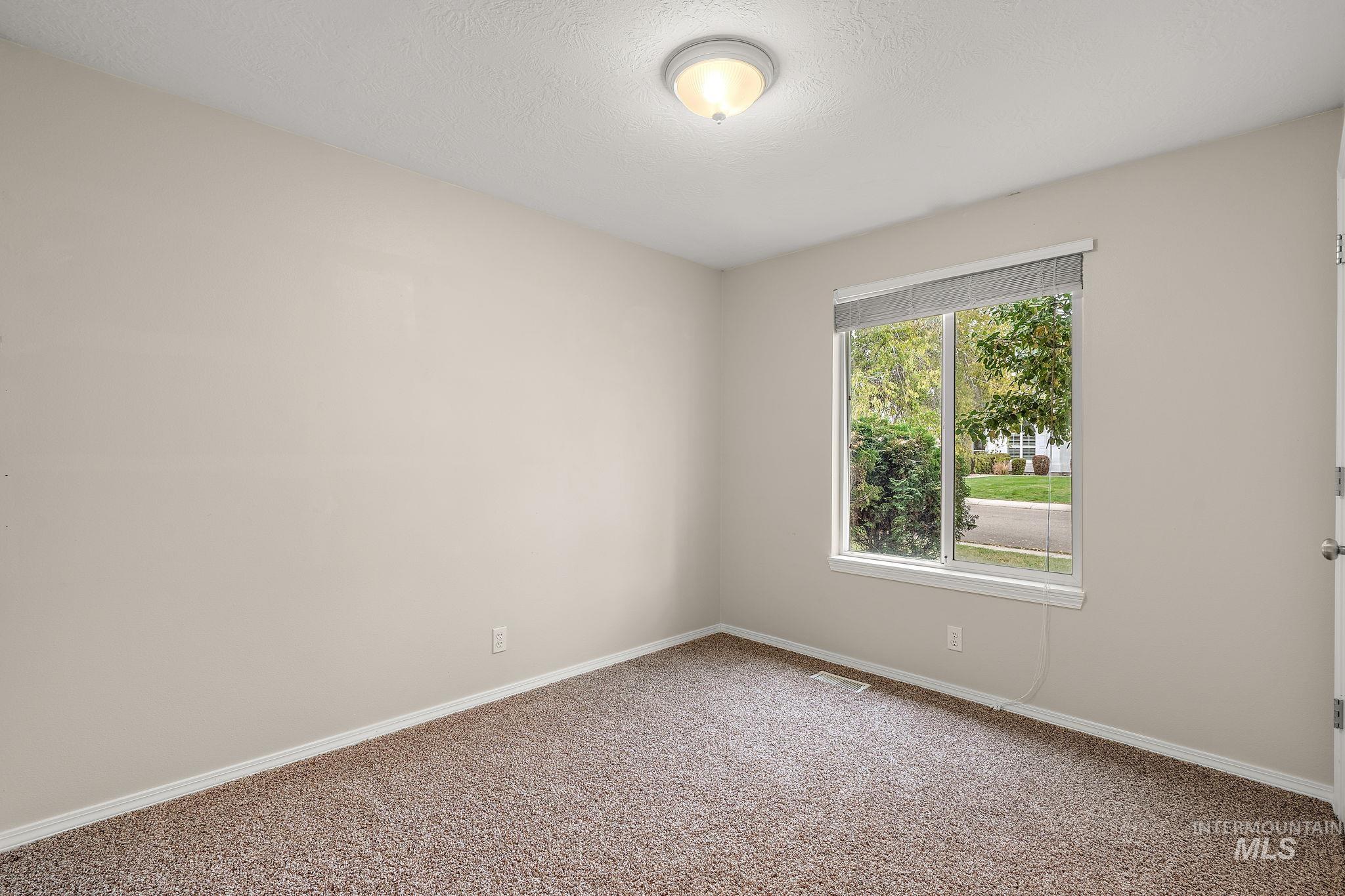 Unfurnished room featuring carpet floors and a textured ceiling