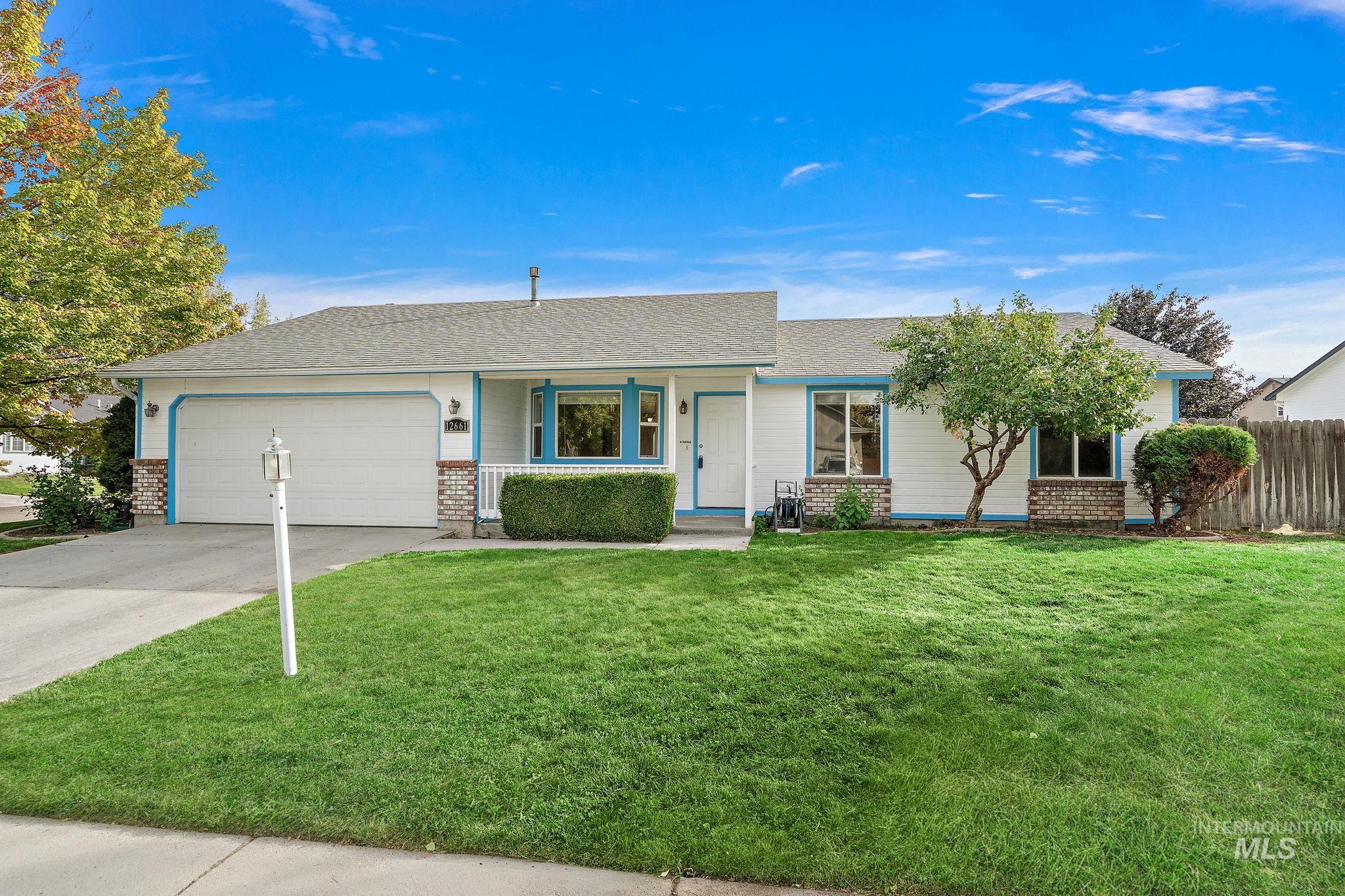 Ranch-style house featuring a porch, brick siding, concrete driveway, and an attached garage