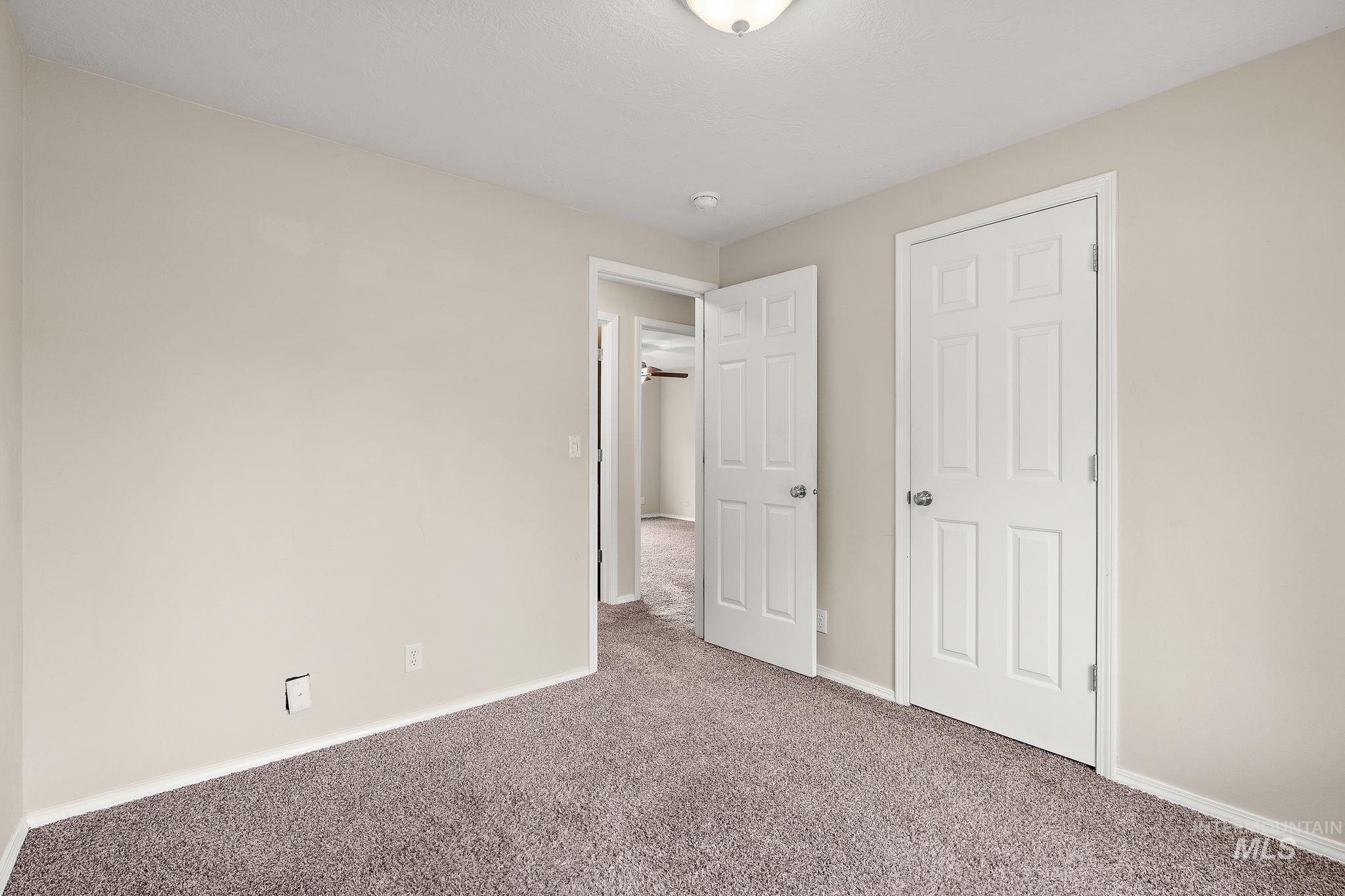 Unfurnished bedroom with carpet flooring and baseboards