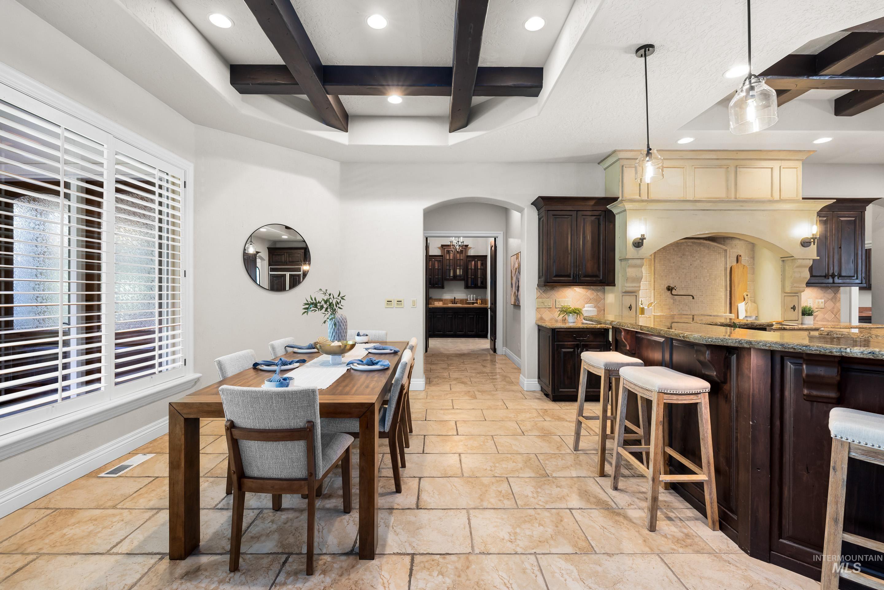 Dining area with coffered ceiling, beamed ceiling, arched walkways, and recessed lighting