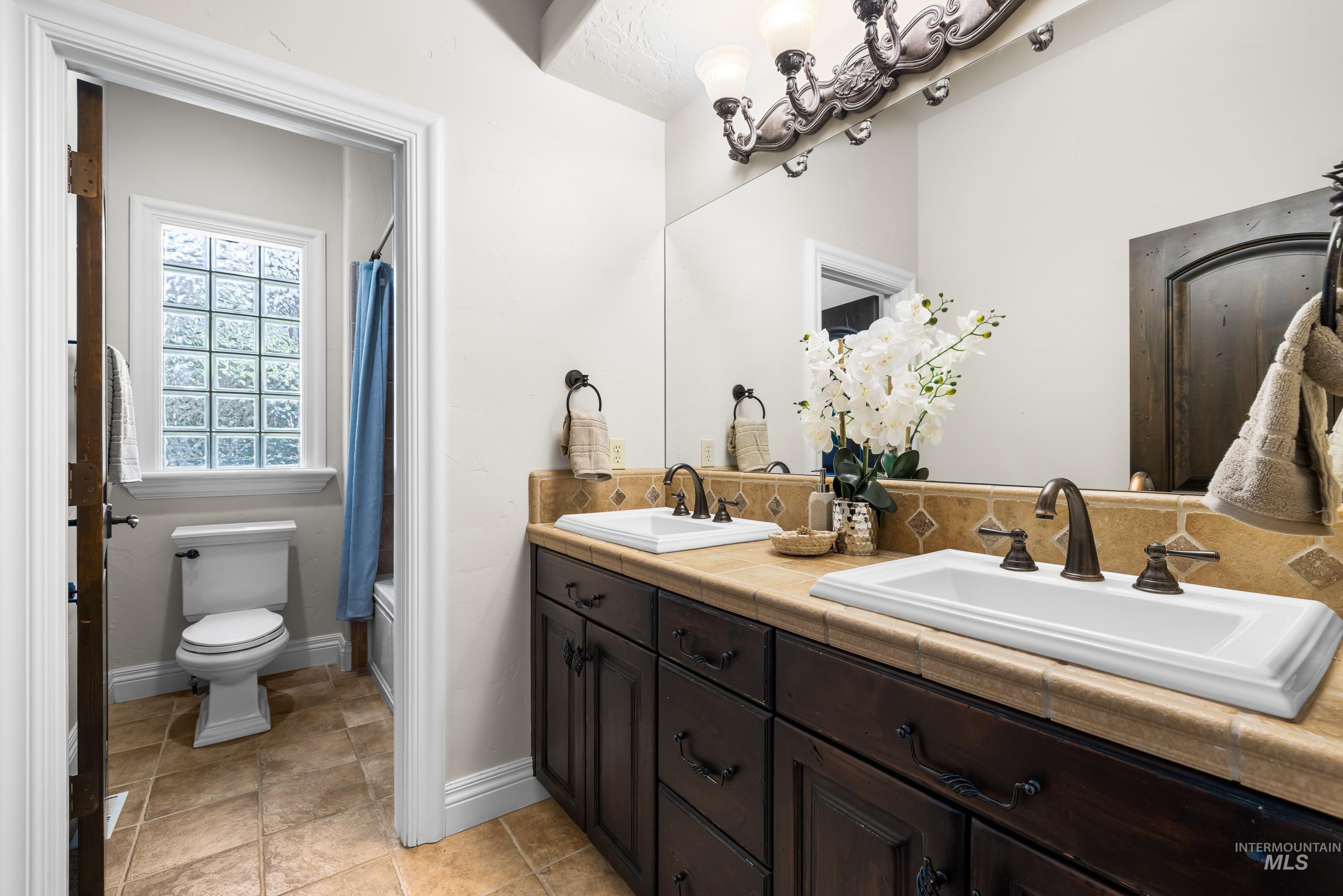 Full bath with double vanity and shower / bath combo