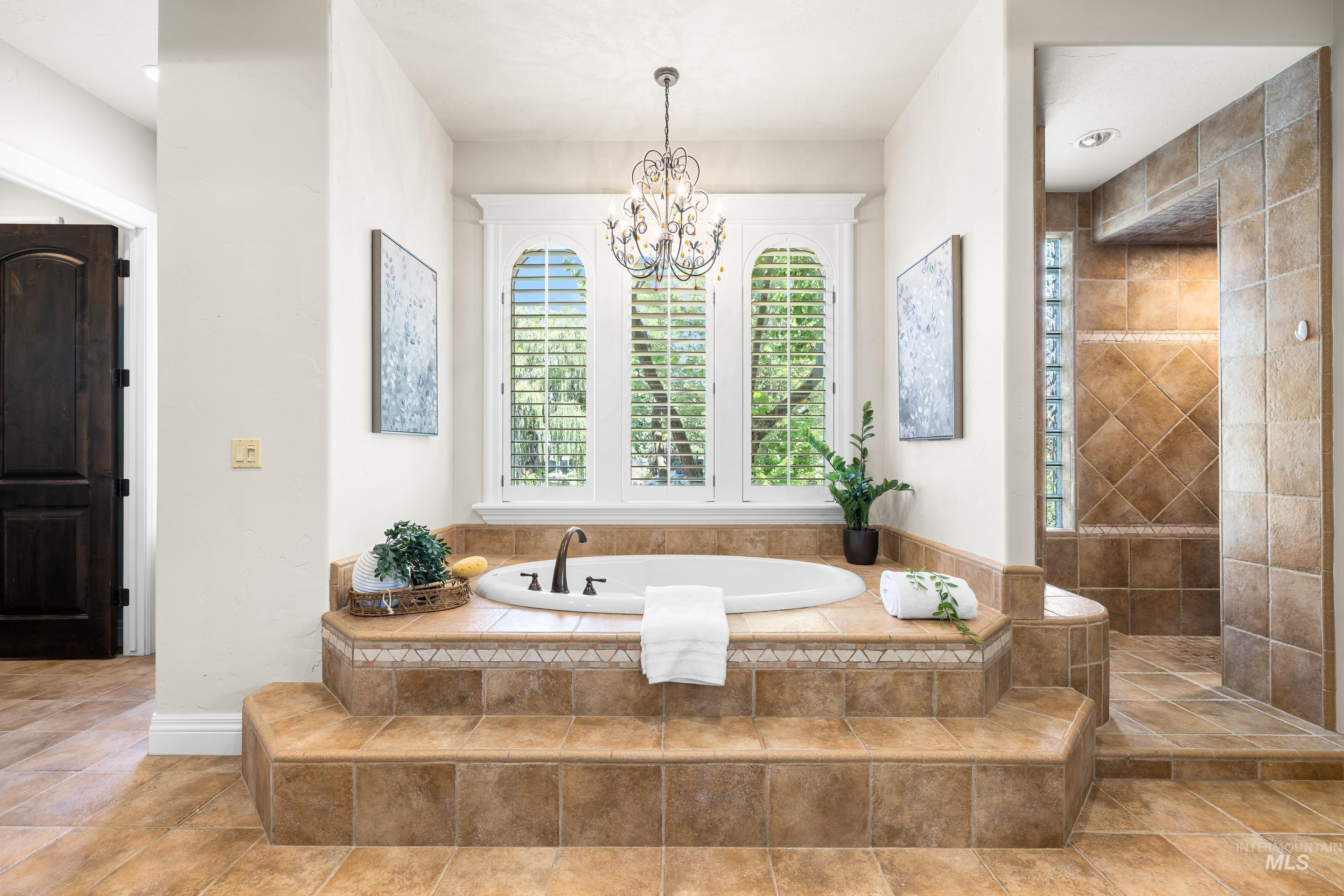 Bathroom with a garden tub and a chandelier