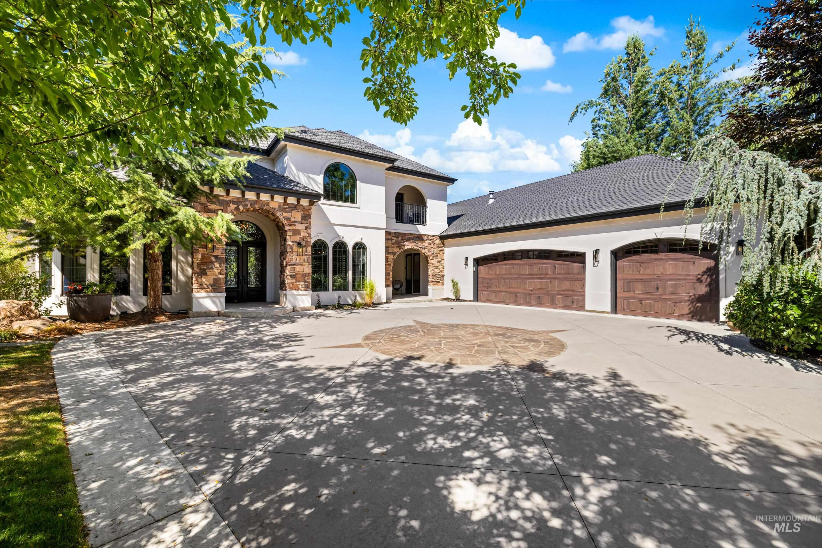Mediterranean / spanish home featuring driveway, a garage, stucco siding, stone siding, and french doors