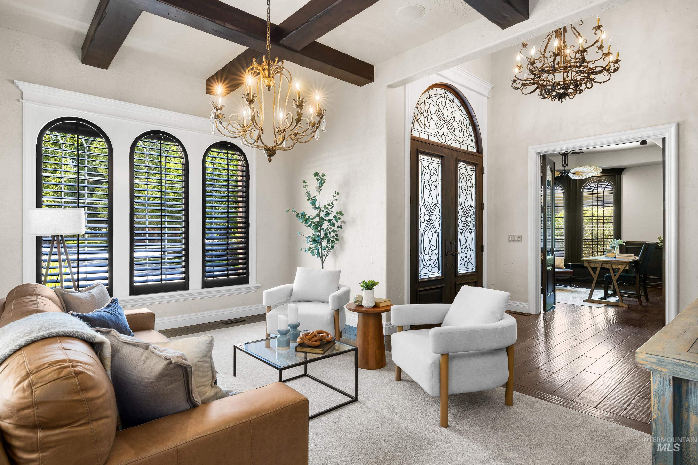 Living room featuring a chandelier, beam ceiling, and wood finished floors