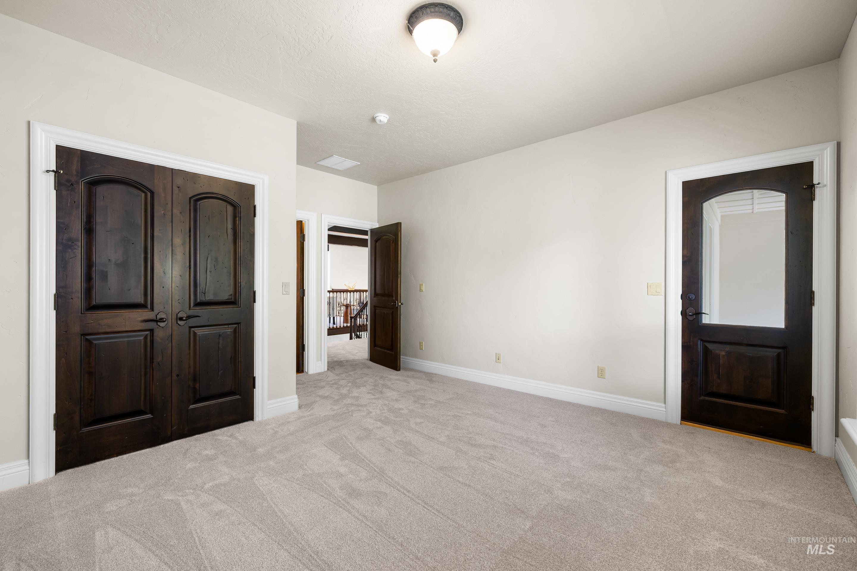 Unfurnished bedroom with carpet flooring and baseboards