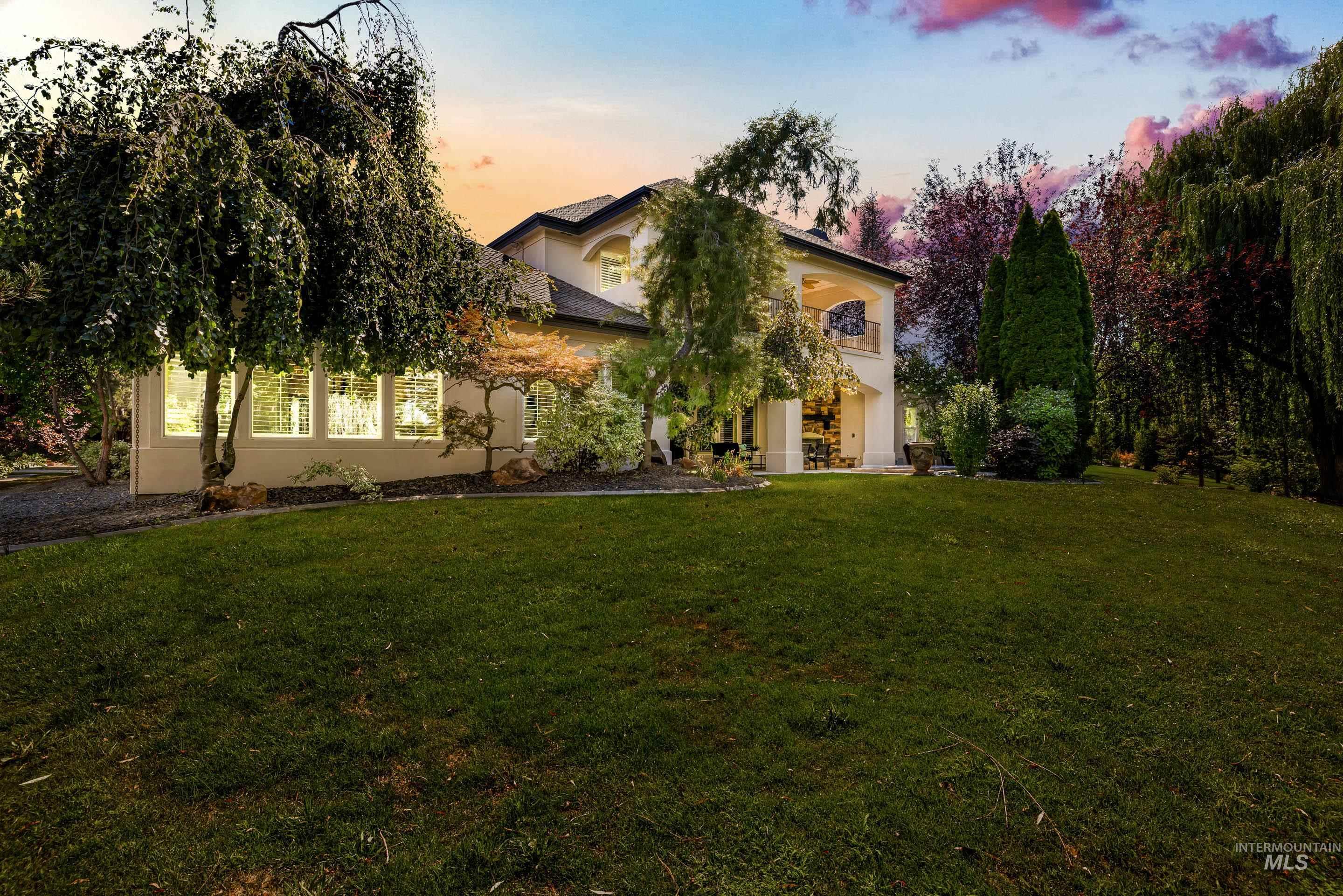 View of front of home featuring stucco siding, a front yard, and a balcony