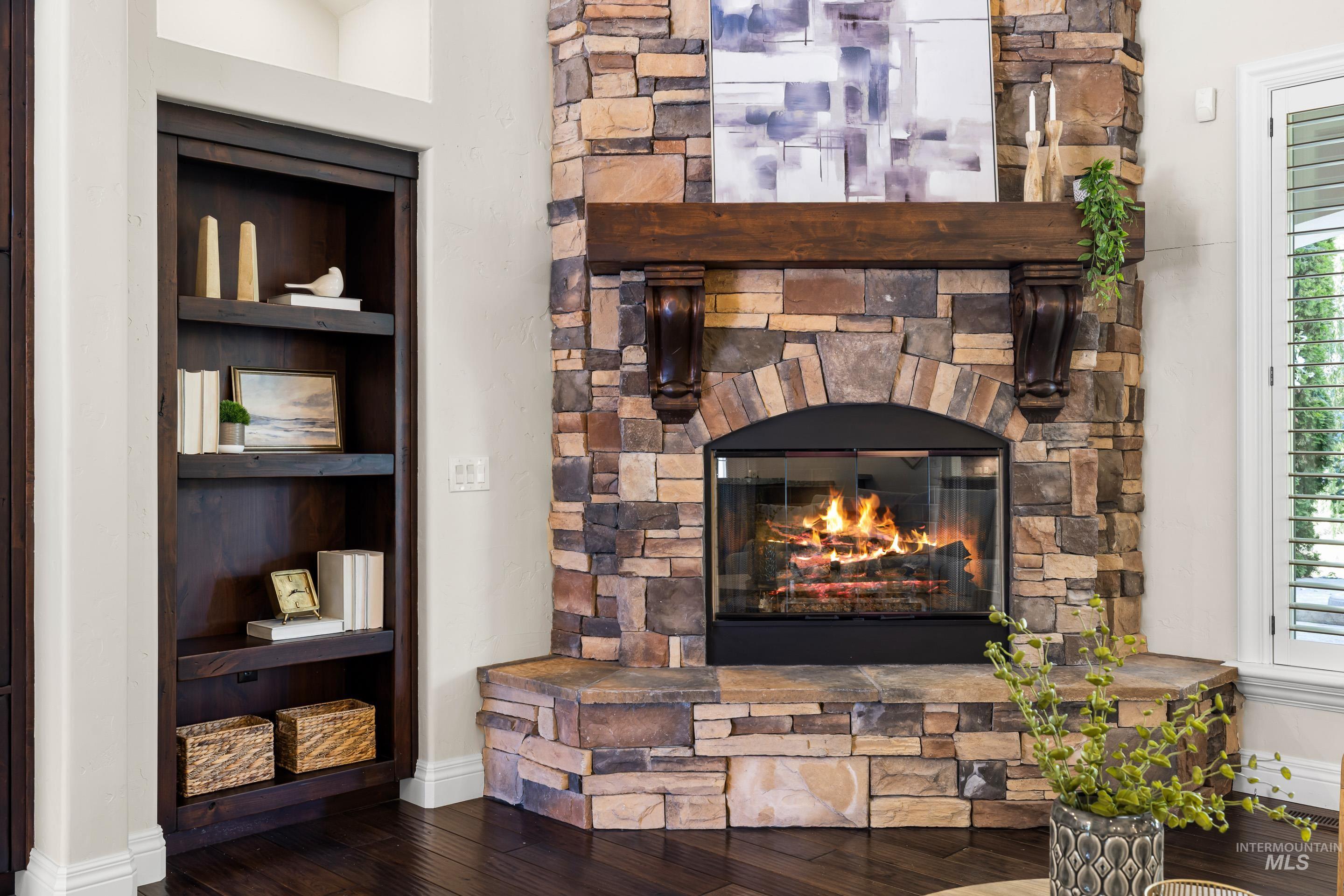 Detailed view of wood finished floors and a stone fireplace