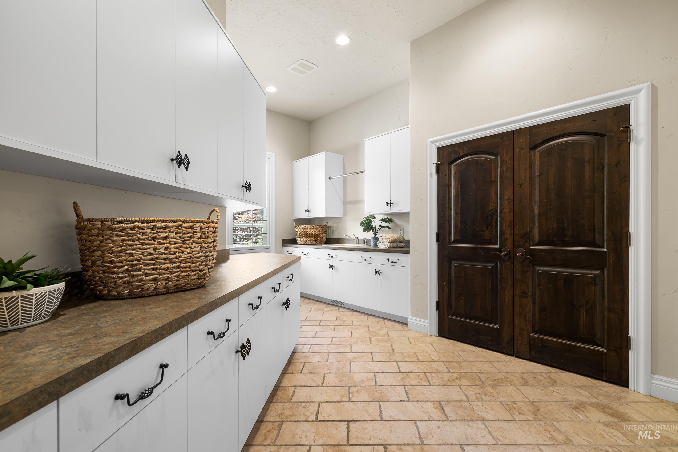 Kitchen with dark countertops, white cabinets, and recessed lighting