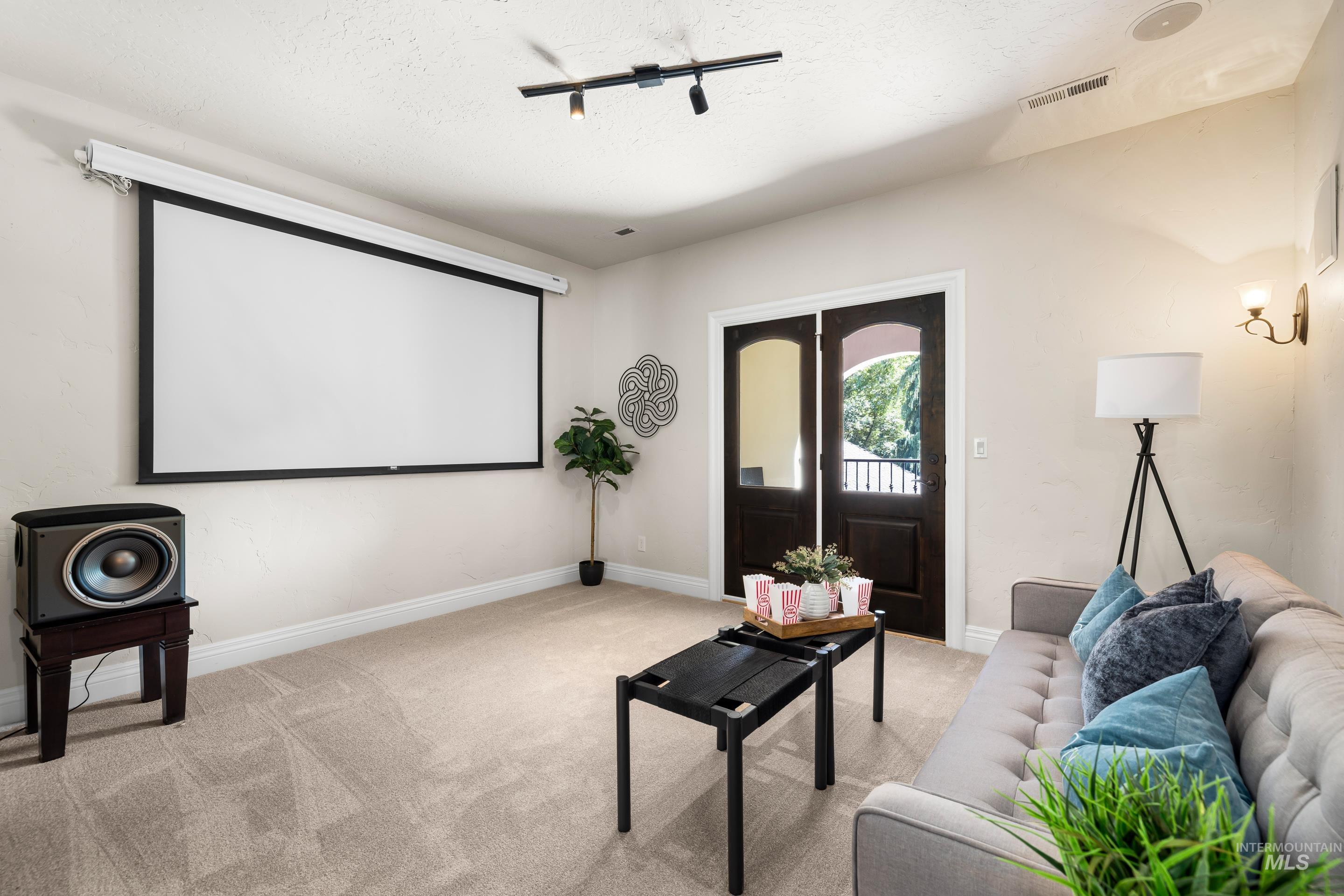 Home theater featuring light colored carpet and baseboards