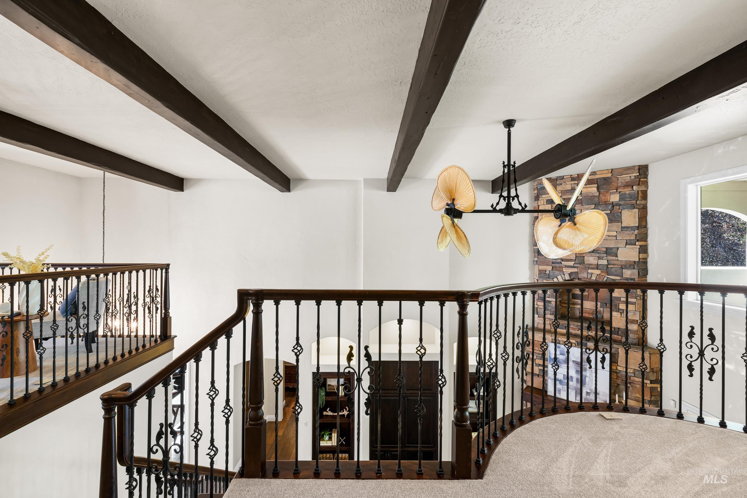 Hallway with a chandelier, a textured ceiling, beam ceiling, and carpet flooring