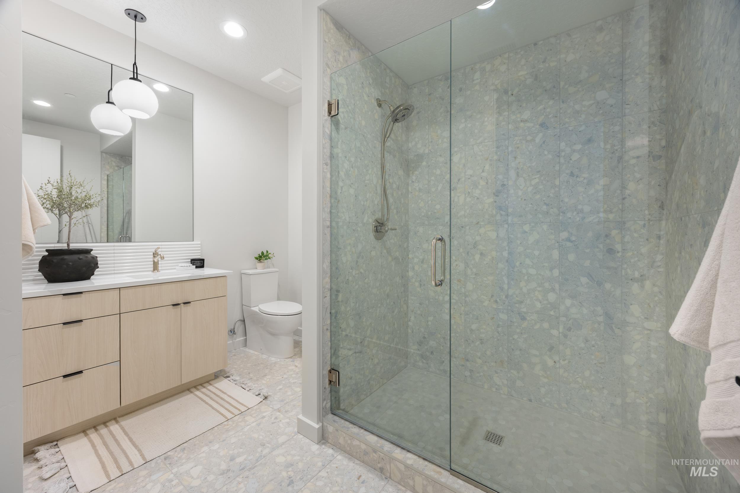 Bathroom with vanity, a stall shower, recessed lighting, and light tile patterned floors