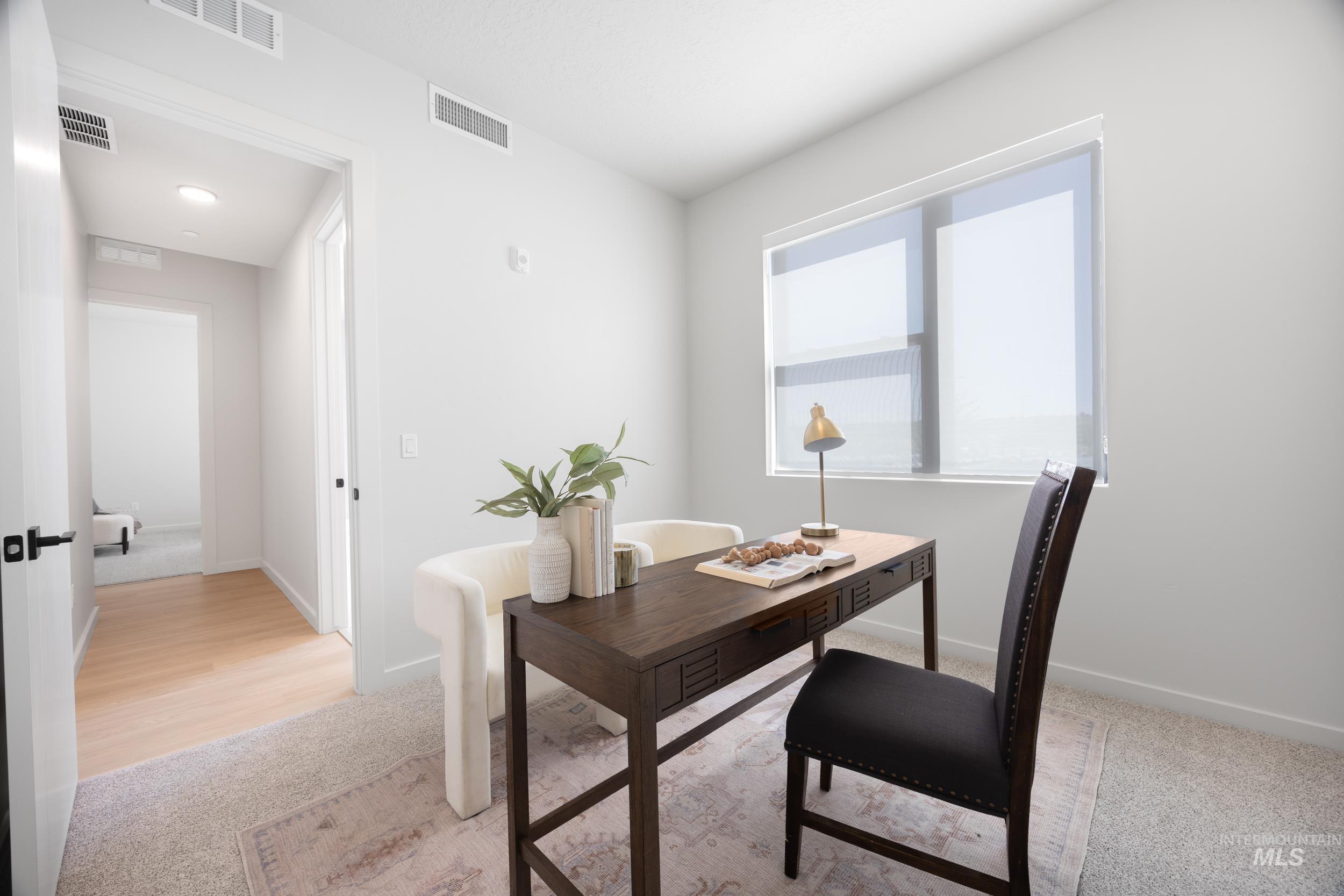 Office space with light carpet and baseboards