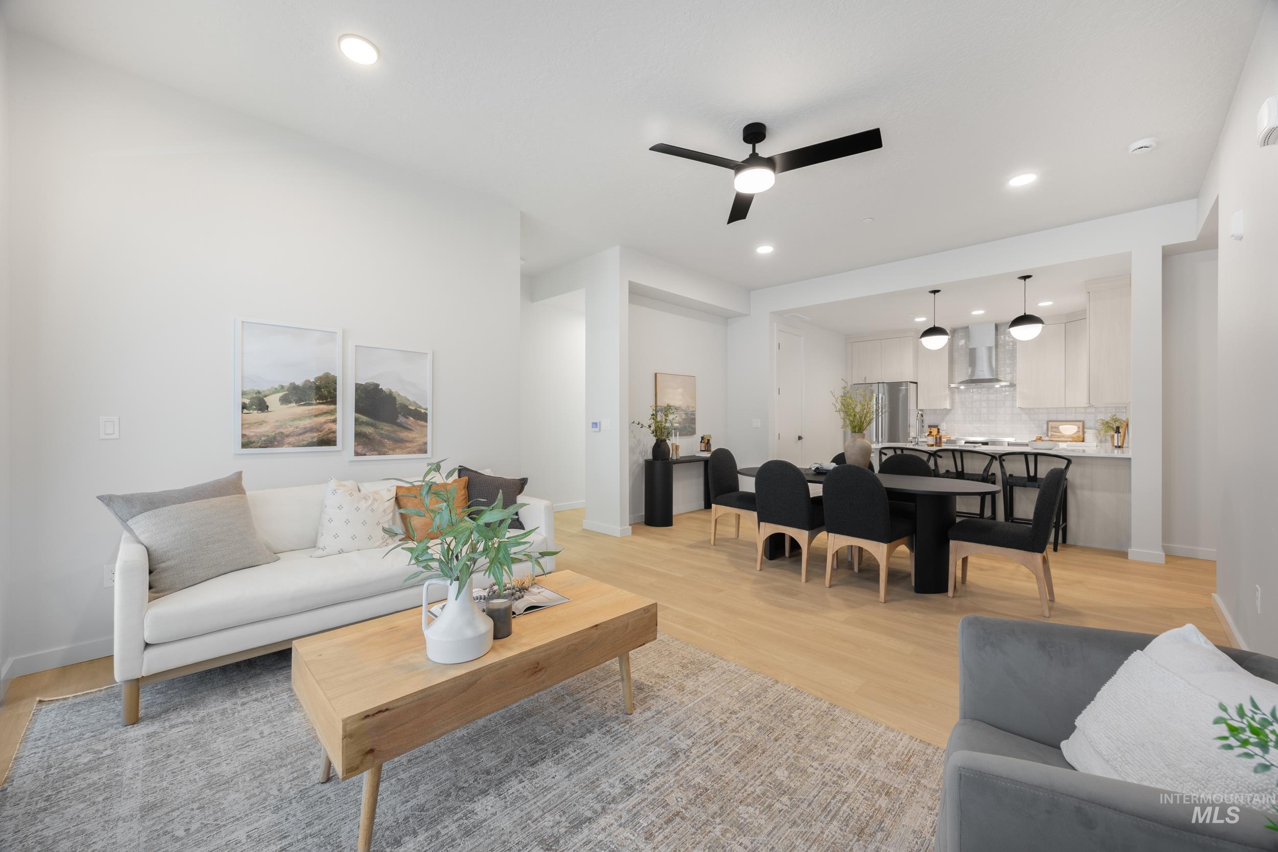 Living area featuring light wood-style floors, ceiling fan, and recessed lighting