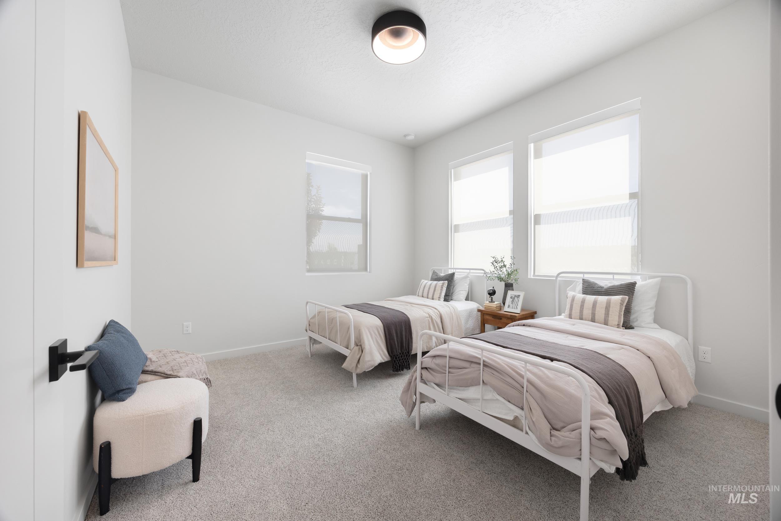 Bedroom with light colored carpet and a textured ceiling