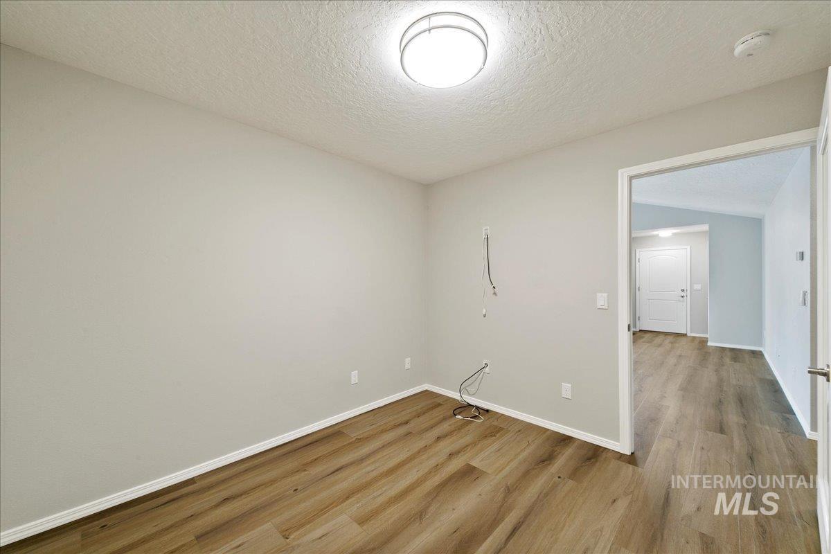 Unfurnished room featuring a textured ceiling and wood finished floors