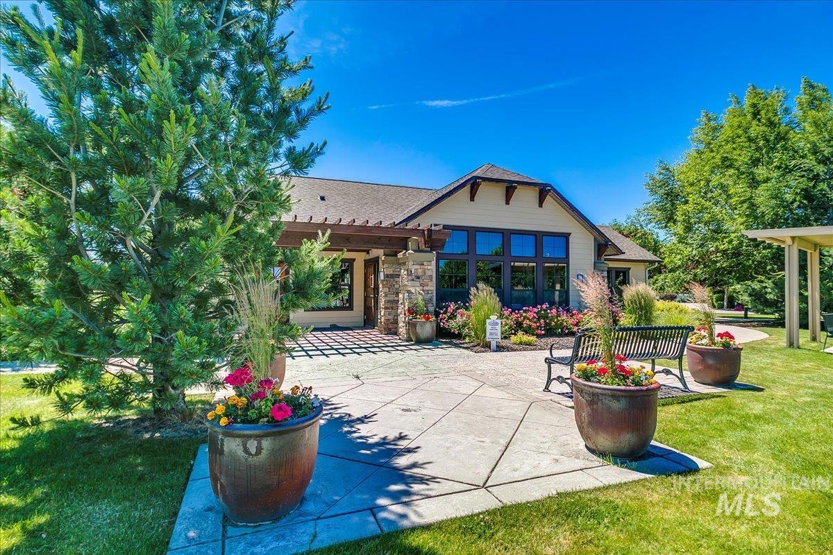 Back of property with a patio area, a pergola, a lawn, stone siding, and a shingled roof