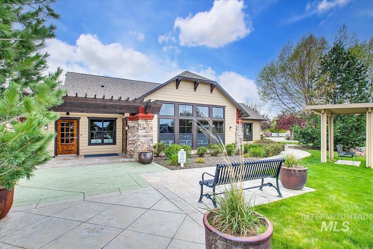 Back of house featuring a patio, a shingled roof, a pergola, and a lawn