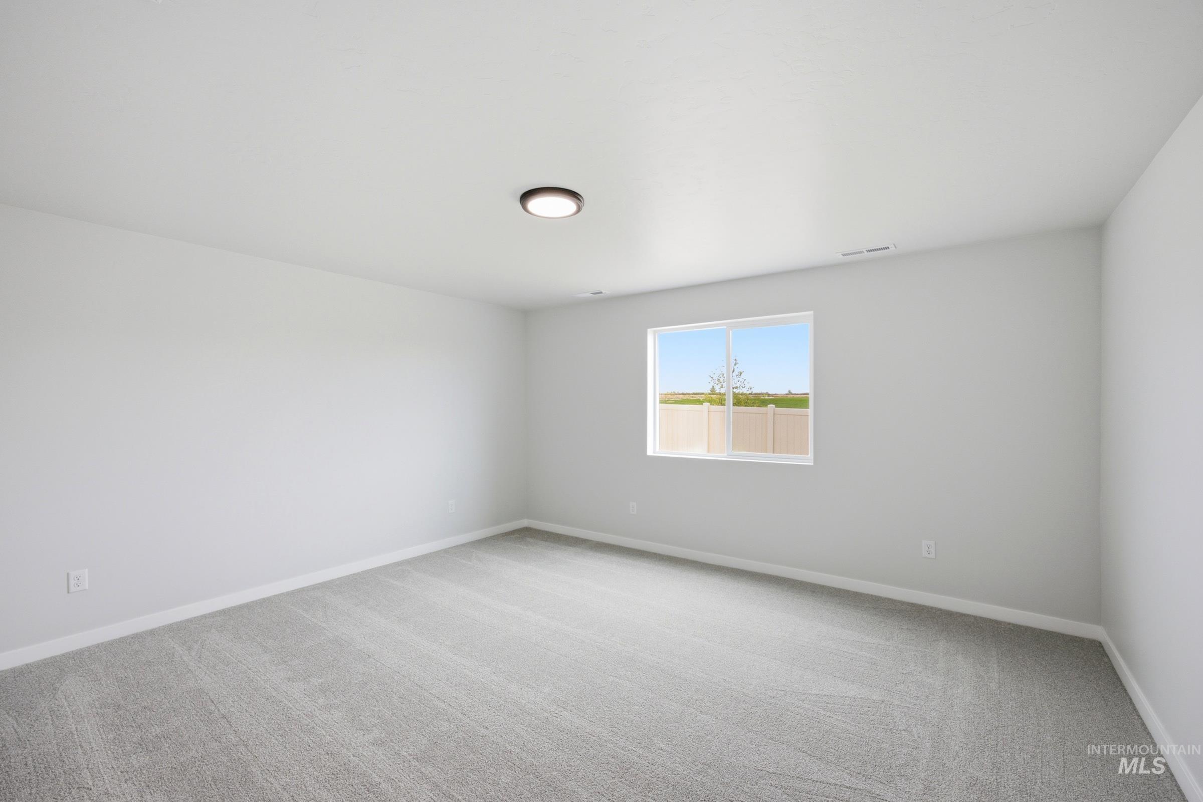 Spacious room featuring light gray carpeting and white walls