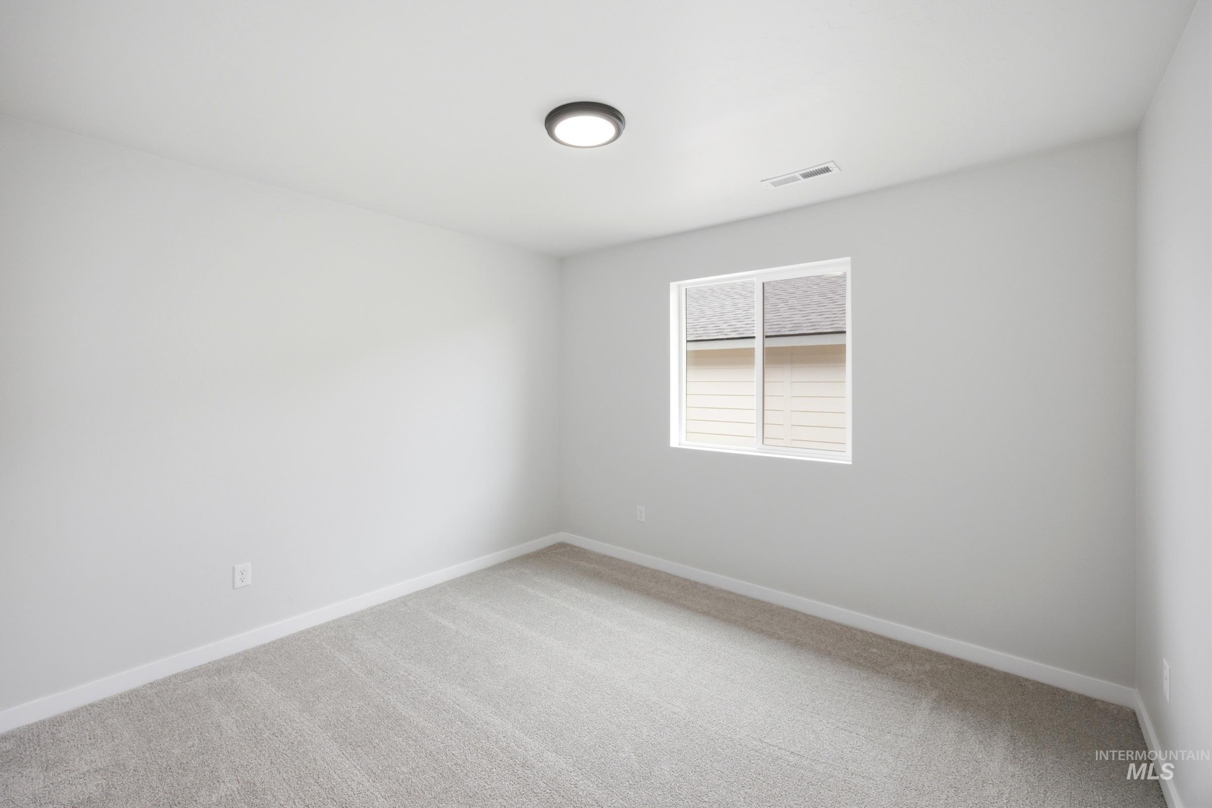 Neutral-toned room featuring a single window, recessed lighting, and light gray wall-to-wall carpeting