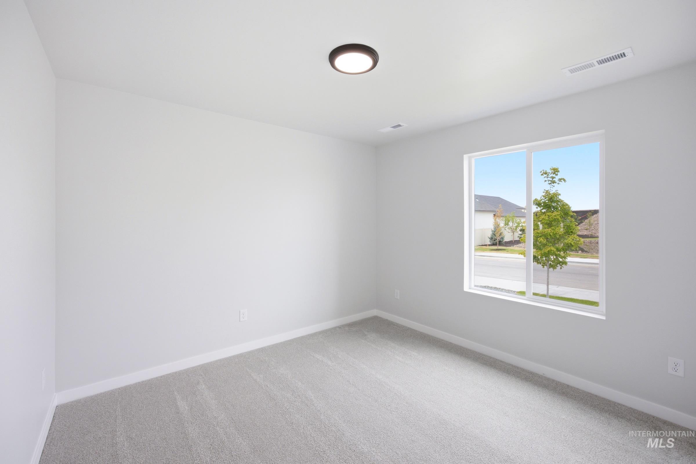 Room featuring light gray carpeting, crisp white walls, and a large window with white trim