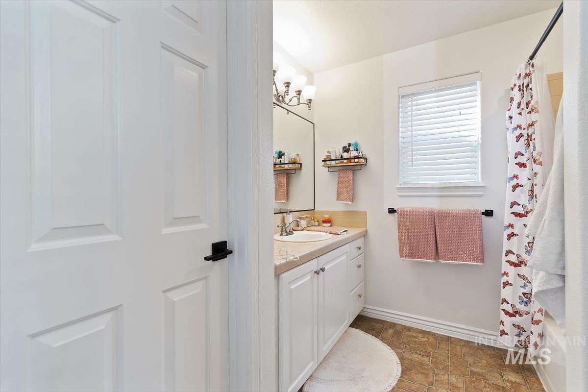 Full bathroom with vanity, a chandelier, and shower / bath combo