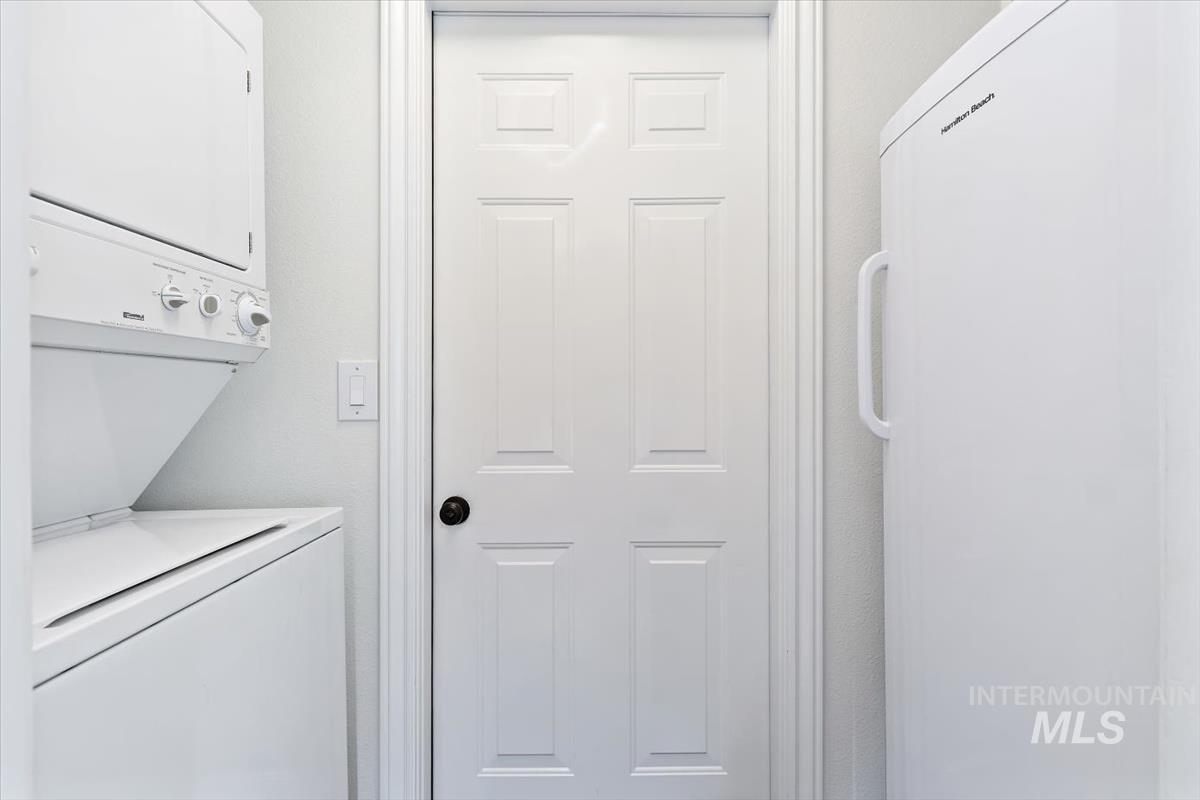 Washroom with stacked washer and clothes dryer