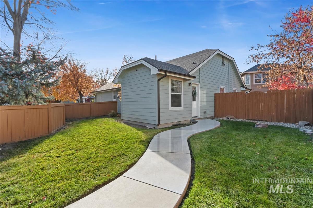Rear view of property featuring a fenced backyard and a shingled roof