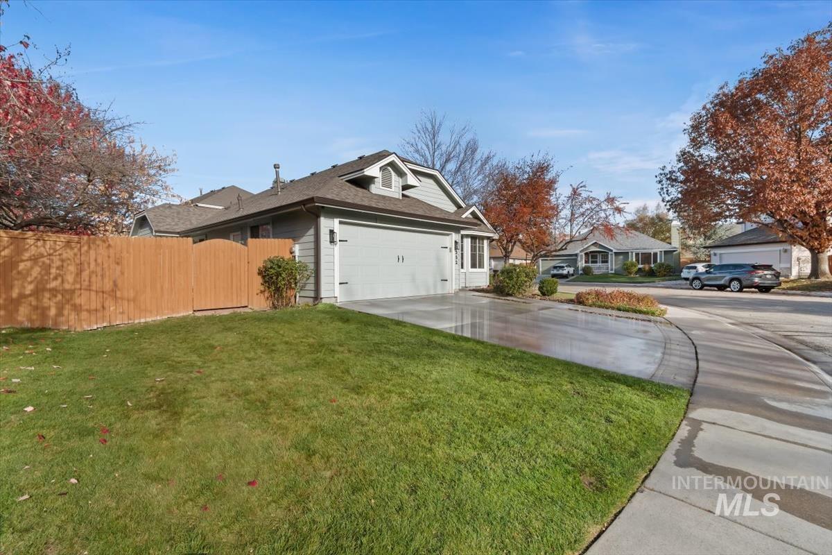 View of side of home with concrete driveway, an attached garage, and roof with shingles