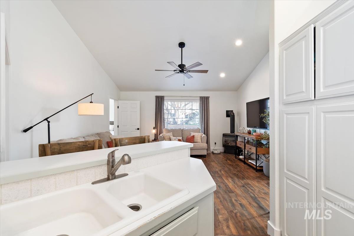 Bathroom featuring lofted ceiling, ceiling fan, dark wood-type flooring, recessed lighting, and vanity