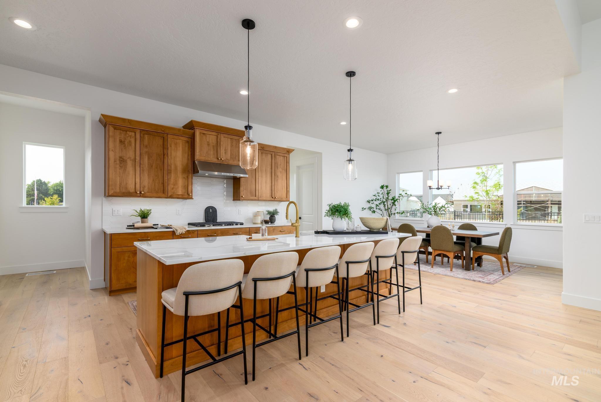 Kitchen featuring brown cabinets, plenty of natural light, decorative light fixtures, and recessed lighting