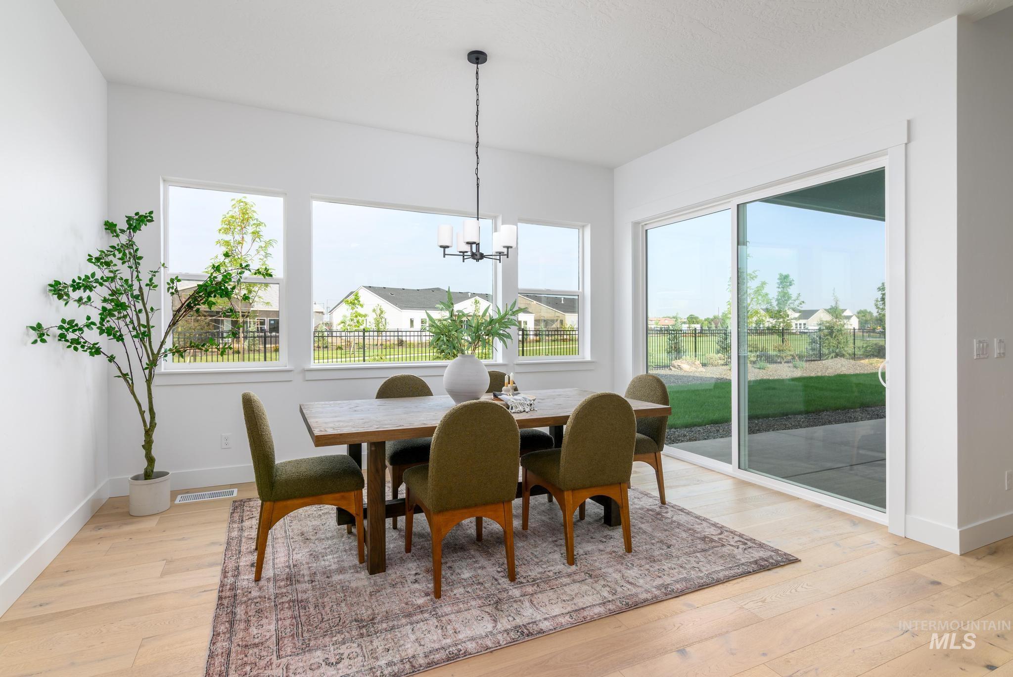 Dining area with light wood-style floors and a chandelier